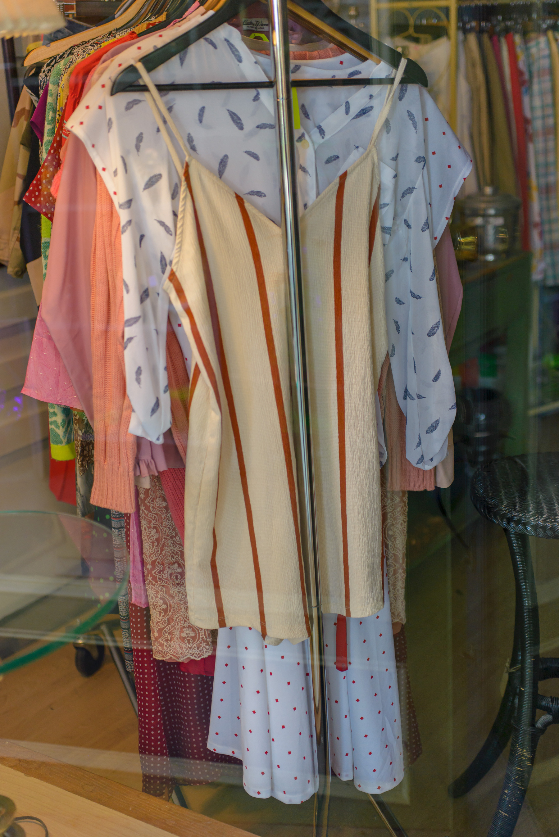 rack of women clothing in a shop, a vertical red striped mini dress, stripes narrow and spaced 3-4 inches apart 