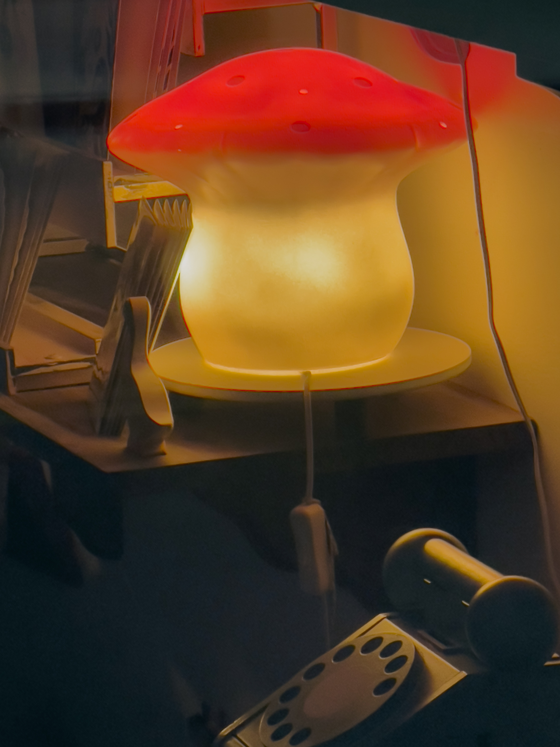 Mushroom lamp in store. Wooden child’s rotary telephone in foreground.