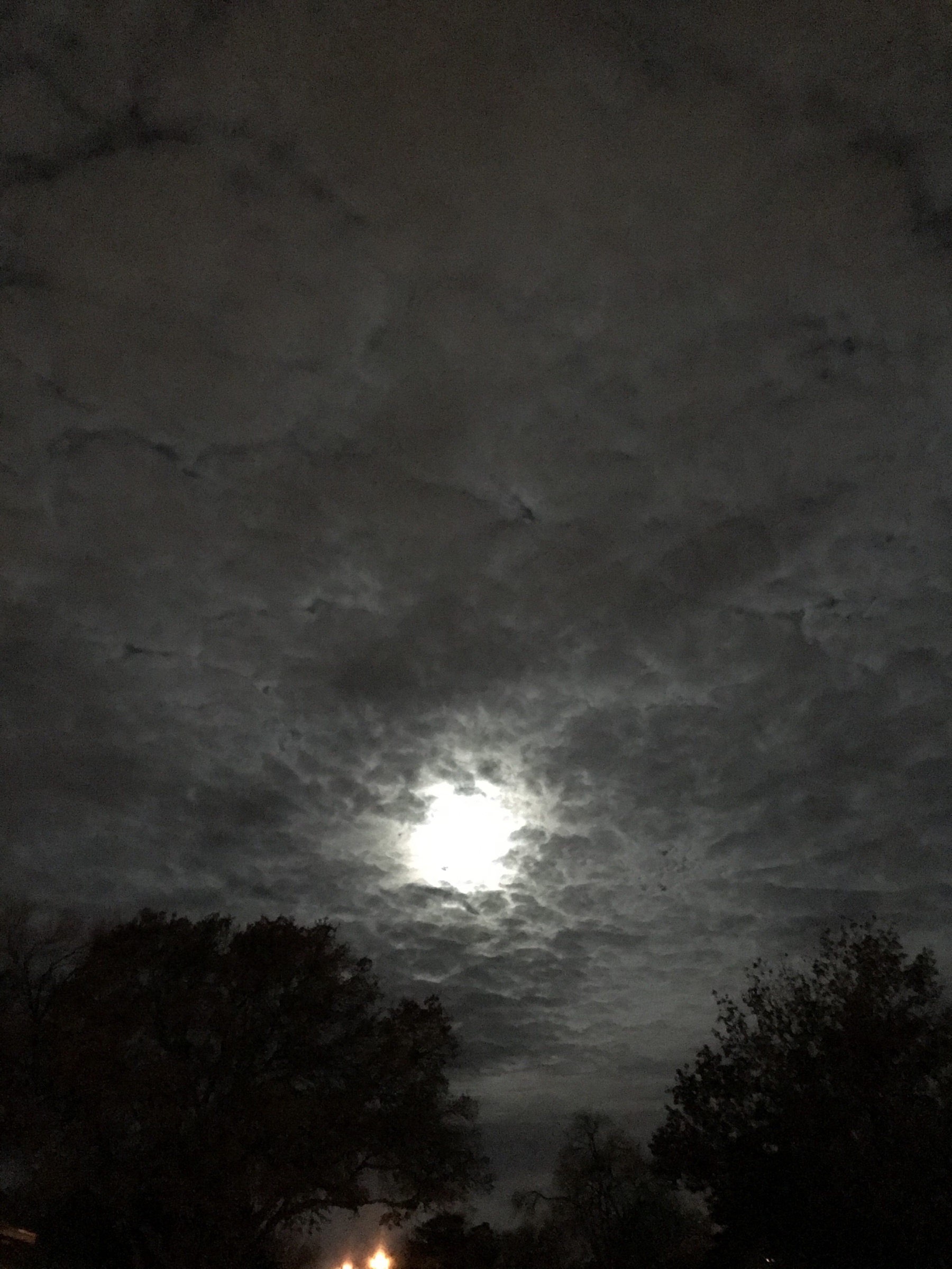 Setting moon shining through patchy clouds