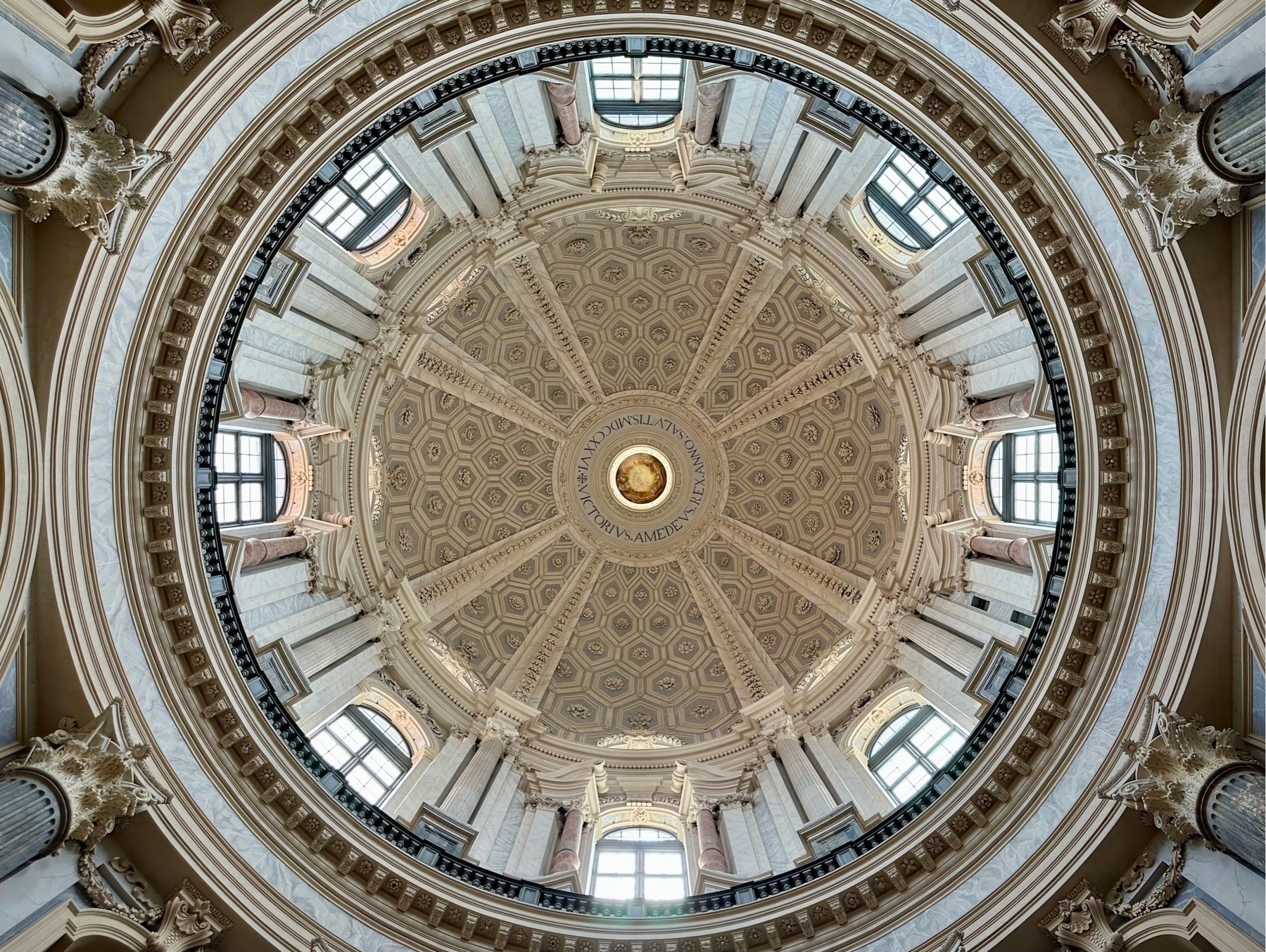 Looking up into a church dome with eight evenly-spaced windows providing the light. Text around the centre gives the year as 1726