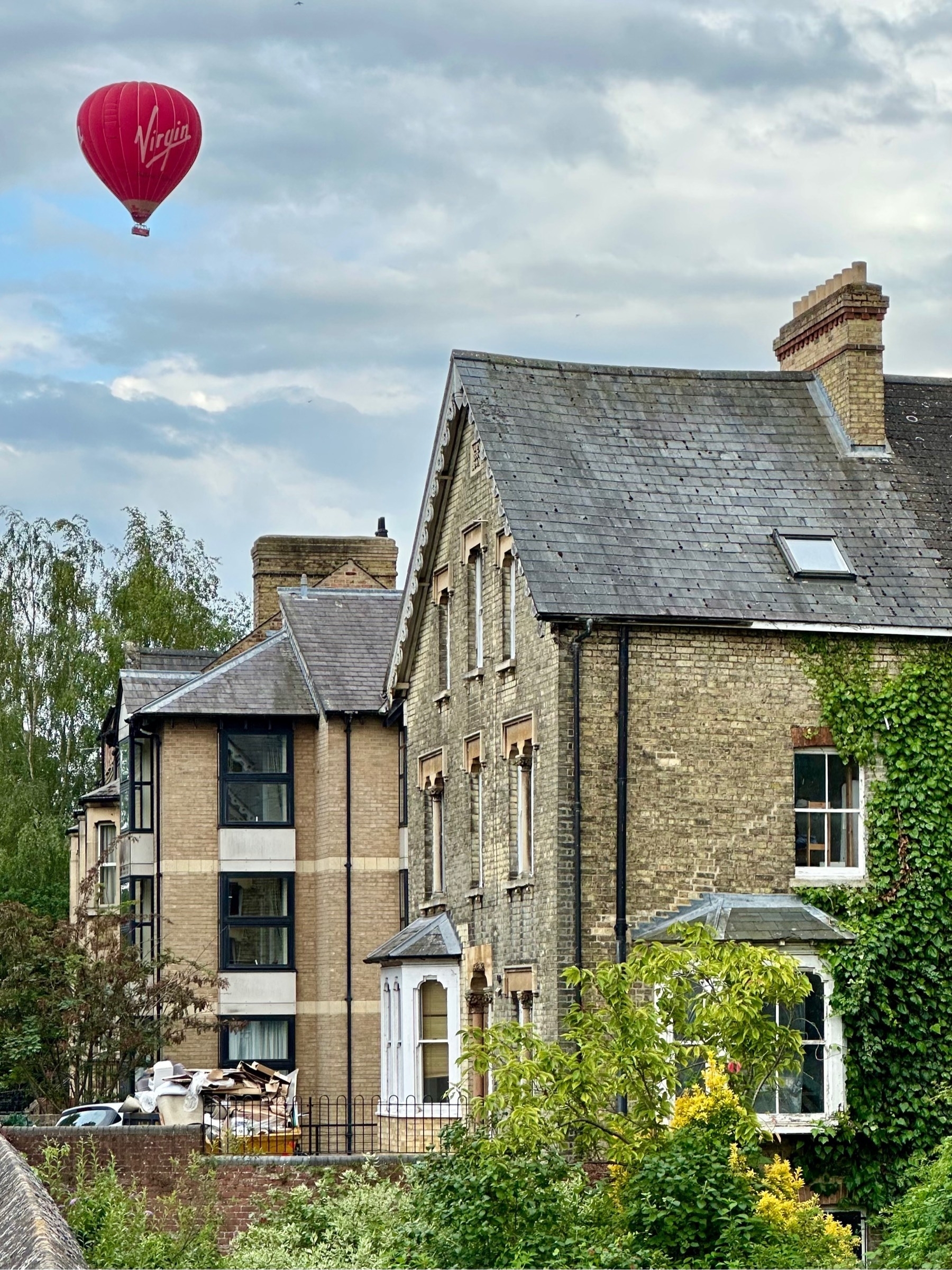 Hot air balloon floating over city houses