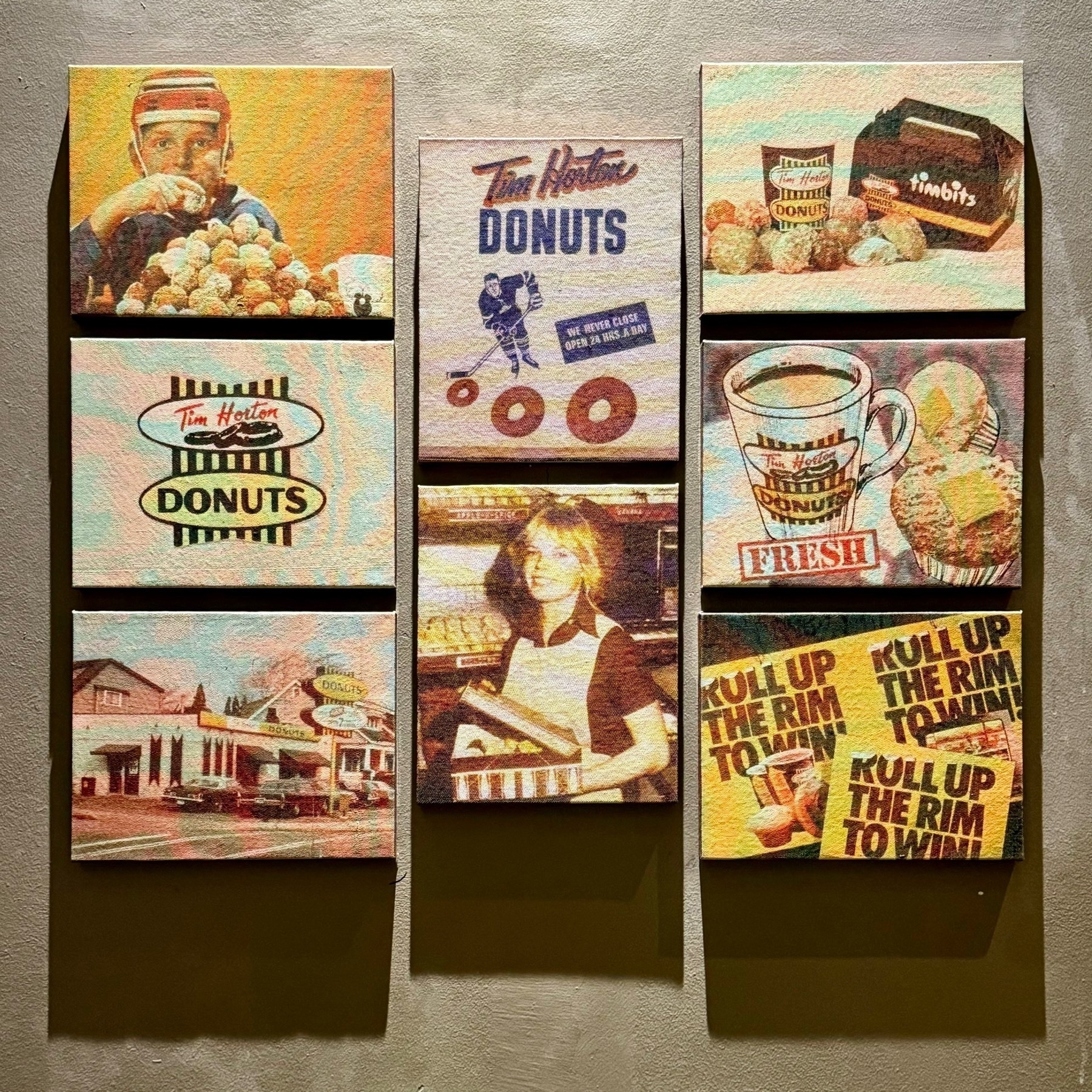 A square of wall covered with eight canvas prints of old Tim Horton advertisements
