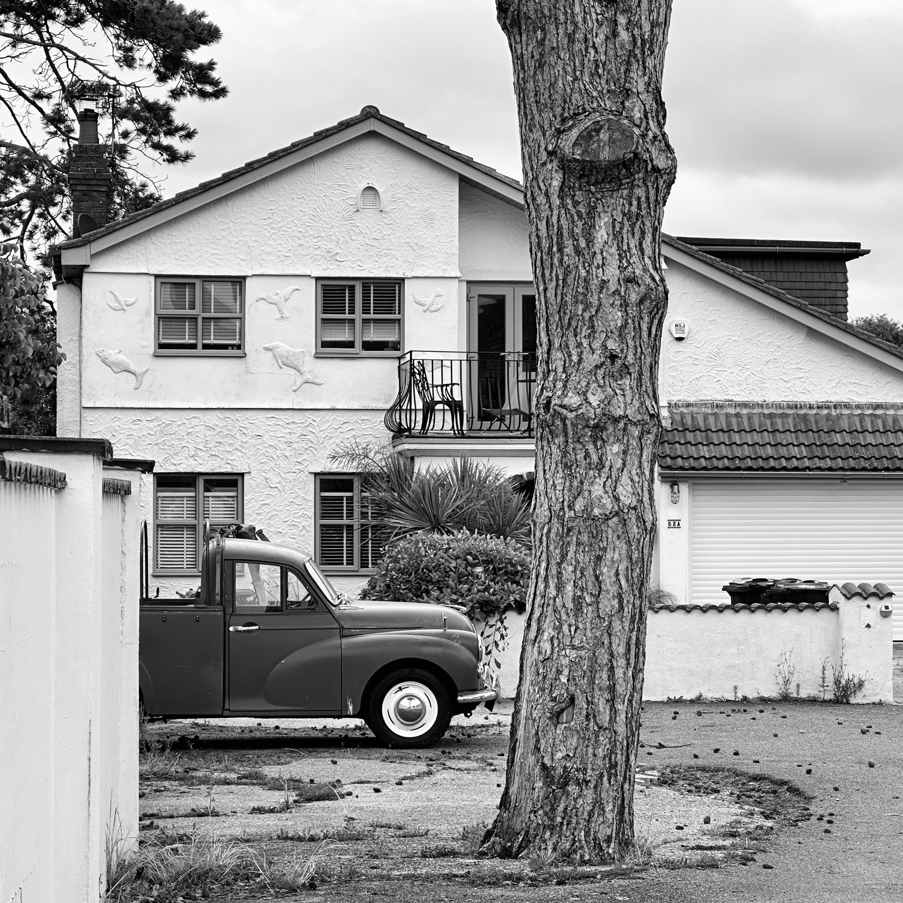 Black and white stylised photo of a house with an old truck parked outside