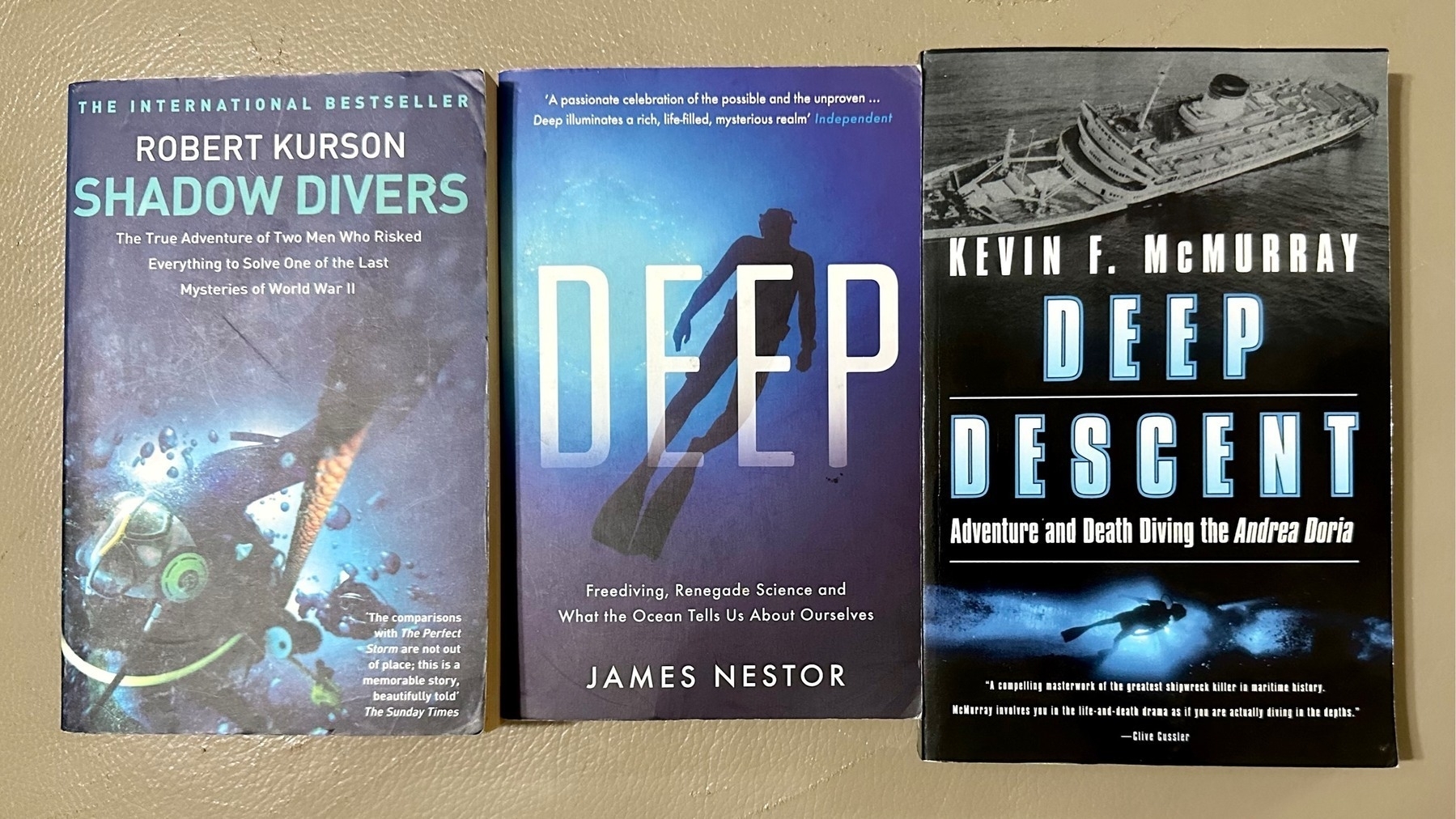 Three paperback books side by side; Shadow Divers, Deep, and Deep Descent