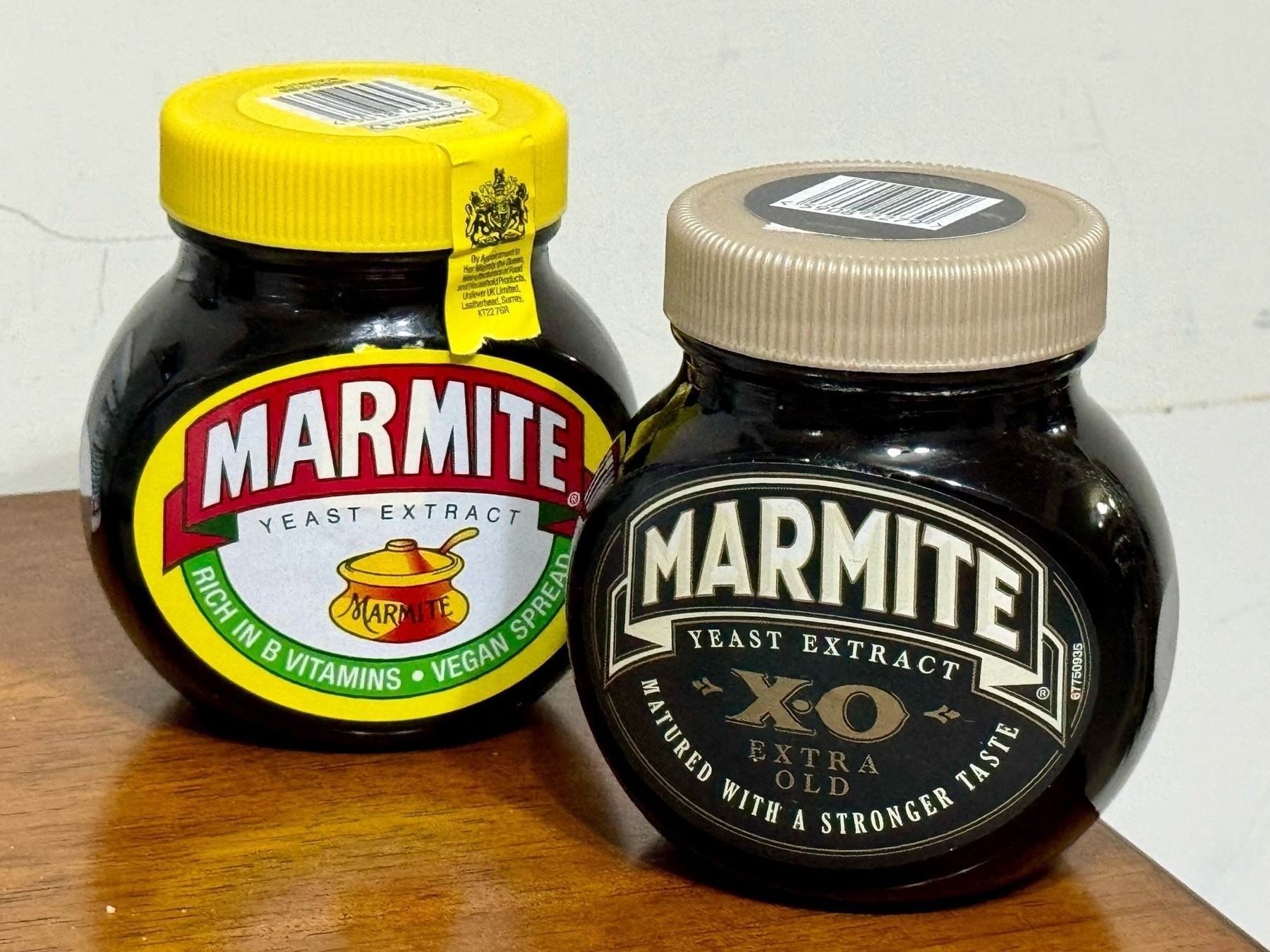 Two jars of Marmite; one normal with a yellow lid, and the XO (extra old/mature) beside it