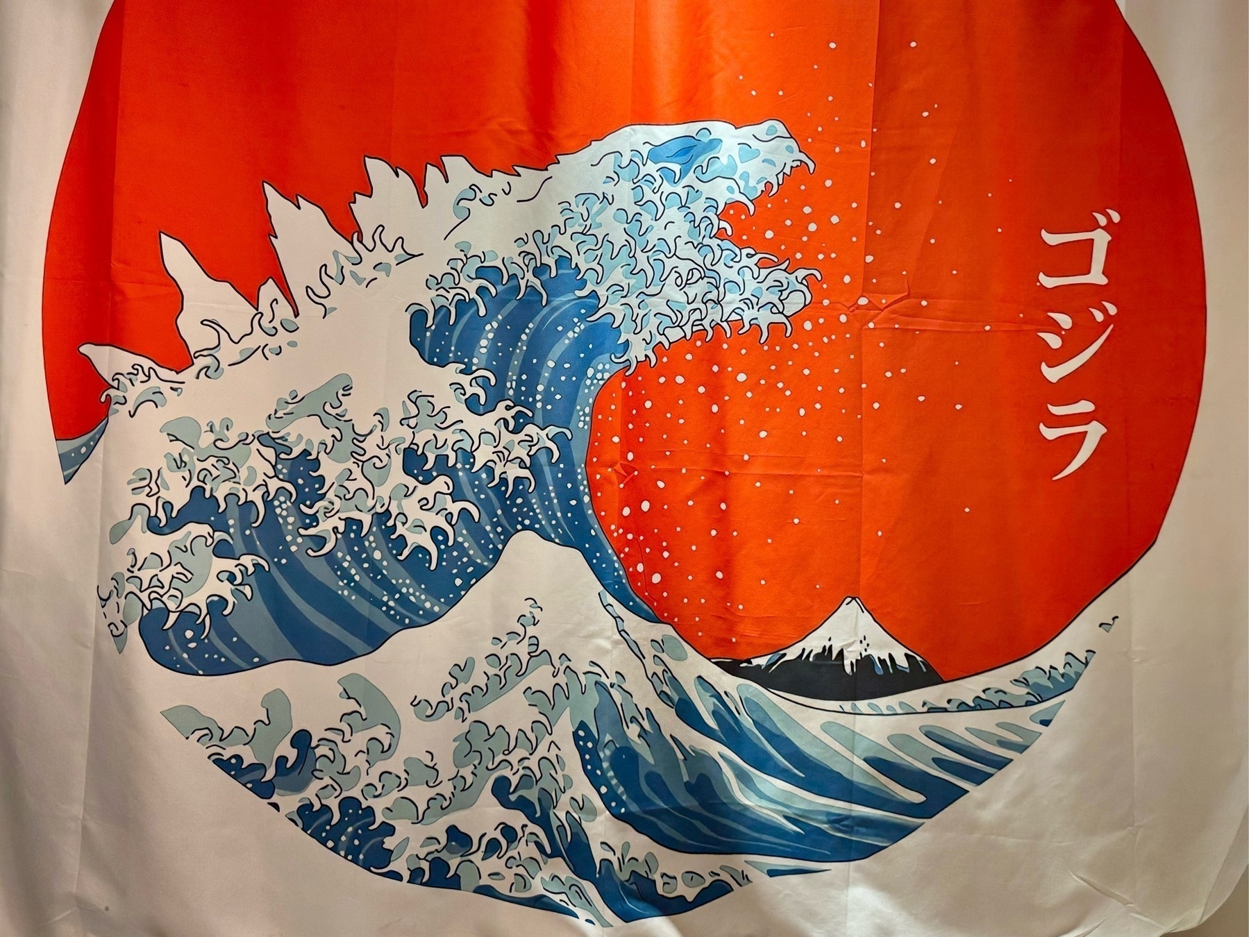 A white flag with a huge red circle in the middle, in which is a painting representative of Hokusai's "The Great Wave off Kanagawa", but with the wave shaped like Godzilla. Labelled with the name "Godzilla" in Japanese.