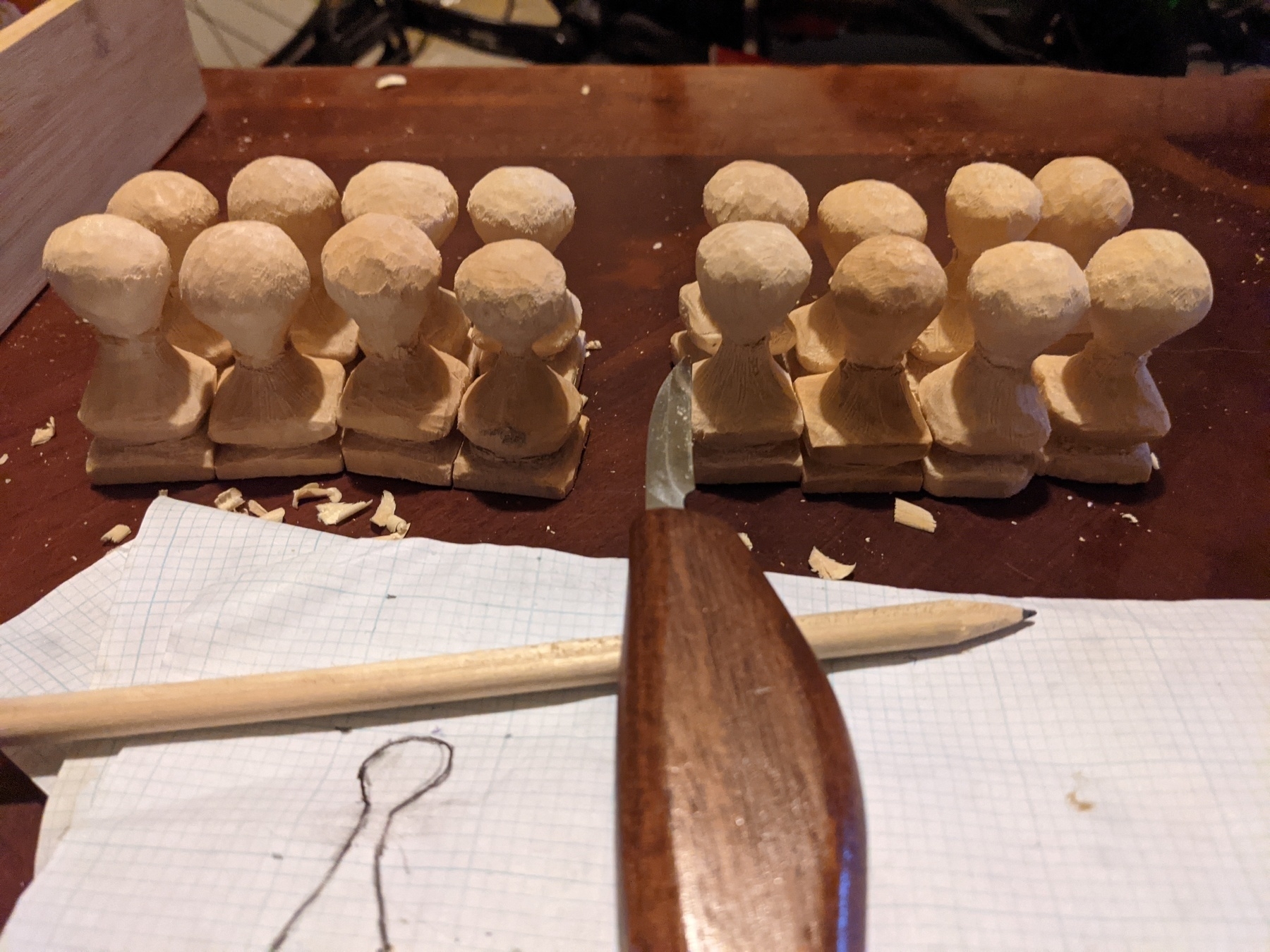 16 pawns carved with a knife in front