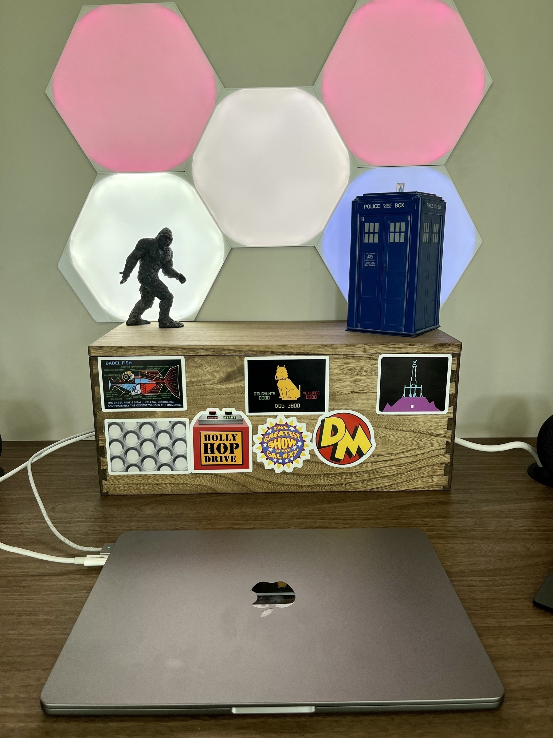 Various geeky stickers, from Doctor Who, to Hitchhiker’s Guide, Red Dwarf and DangerMouse adorn a box. The Tardis and a sasquatch sit on top of the box.