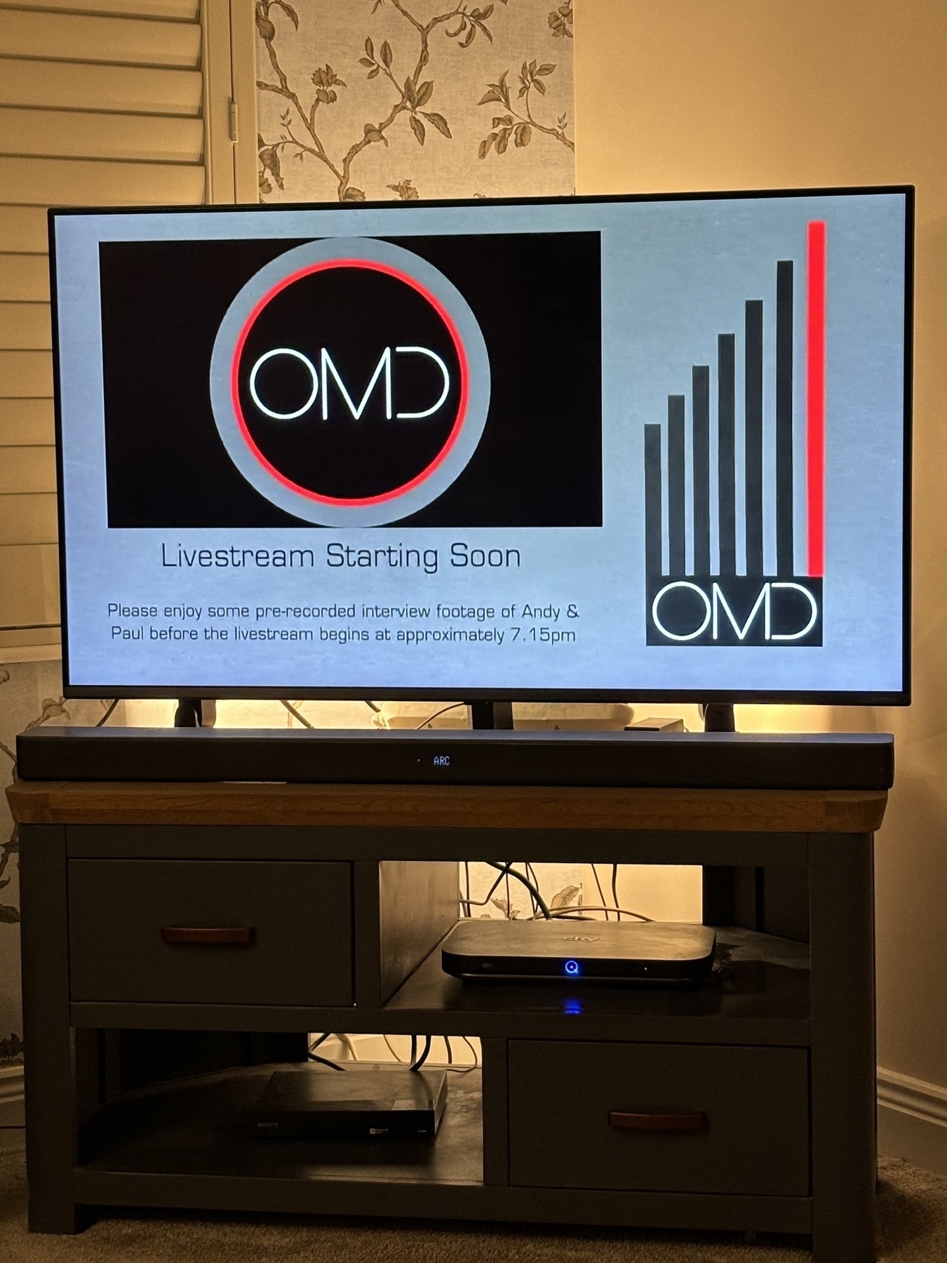 Screenshot of a television showing livestream for OMD’s album launch party. 
