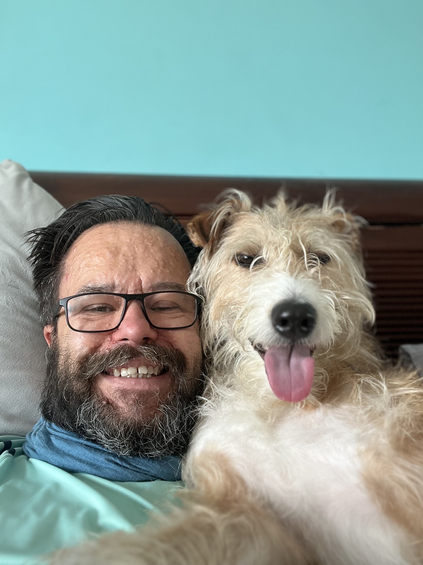 Beardy man with daft smile and daft dog with an even dafter expression. 
