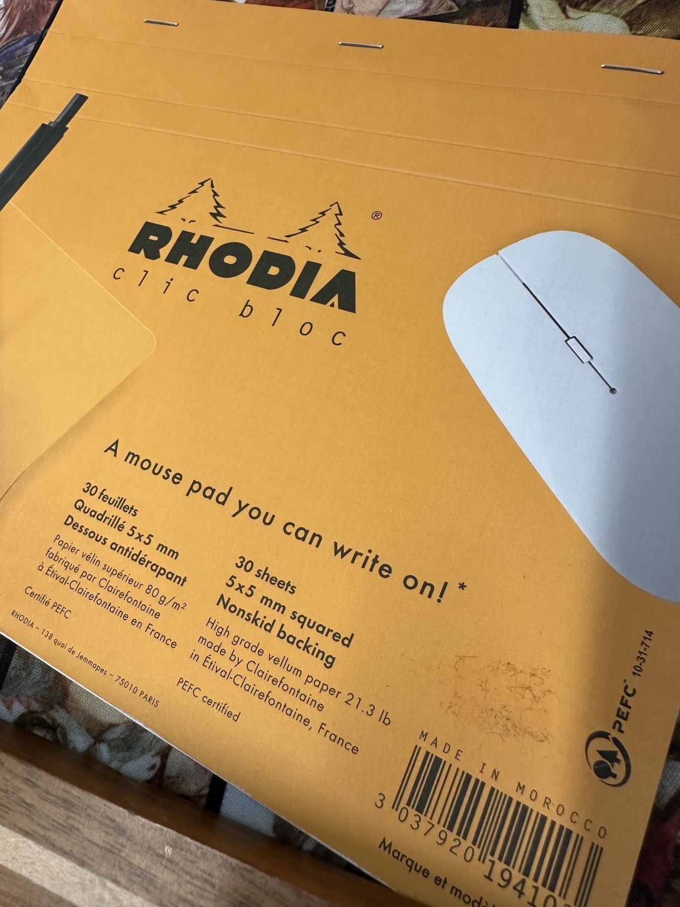 A mouse pad-sized Rhodia notebook that says “A mouse pad you can write on!”