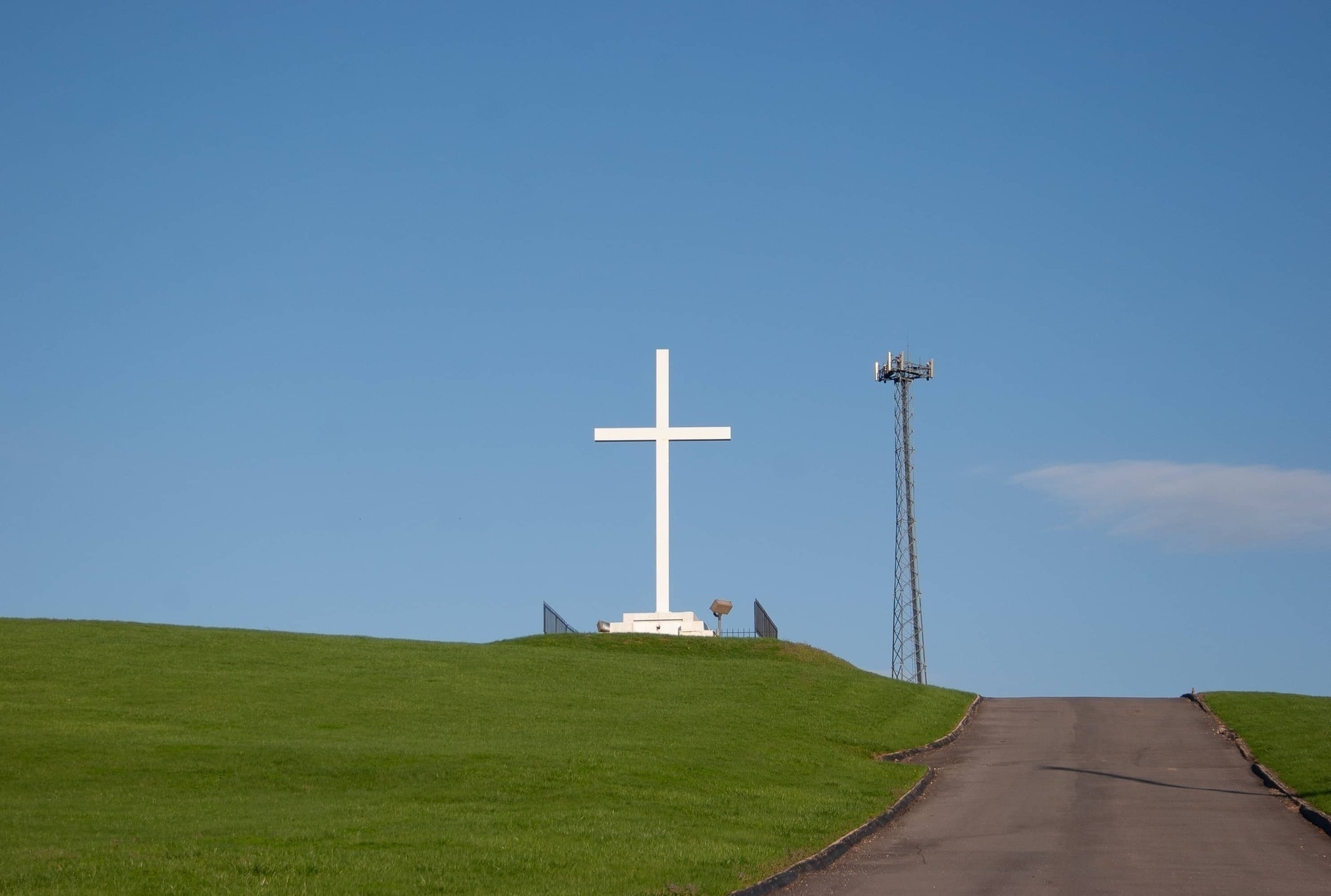 Green grass hill with white cross and cell tower - Canon EOS 20D