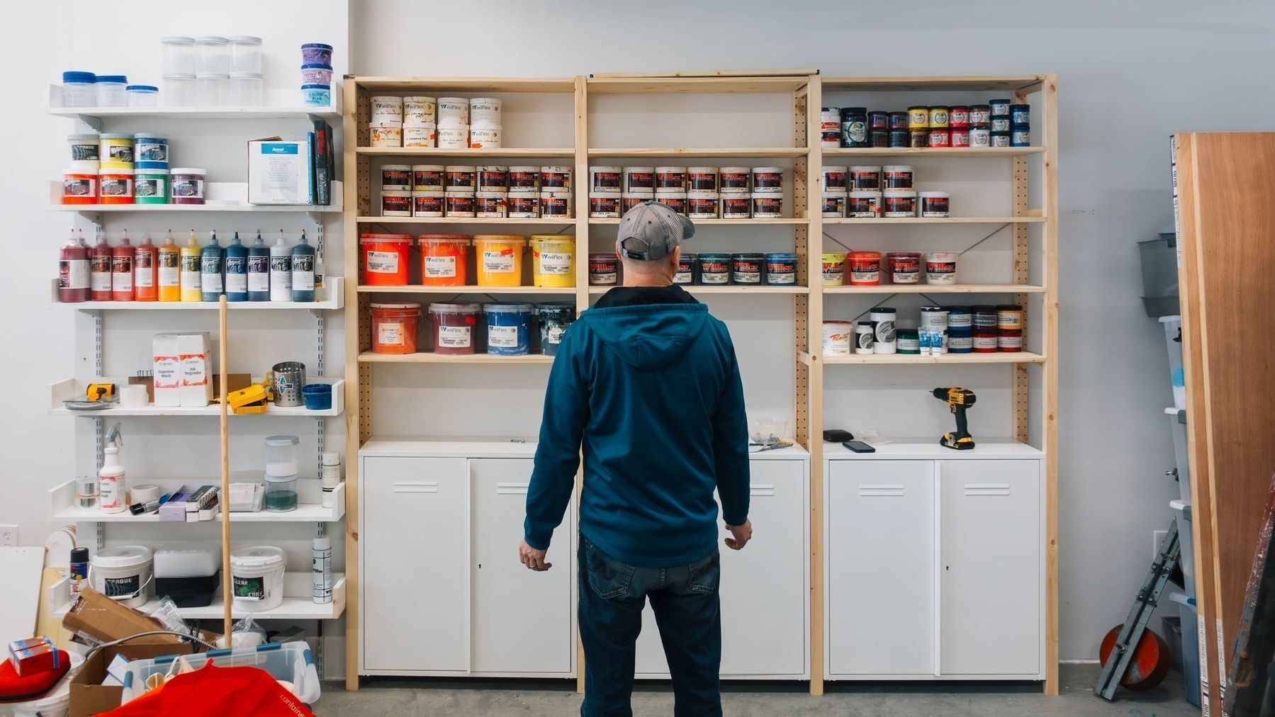 Man looks over colorful inks on wooden shelves - Sony RX100