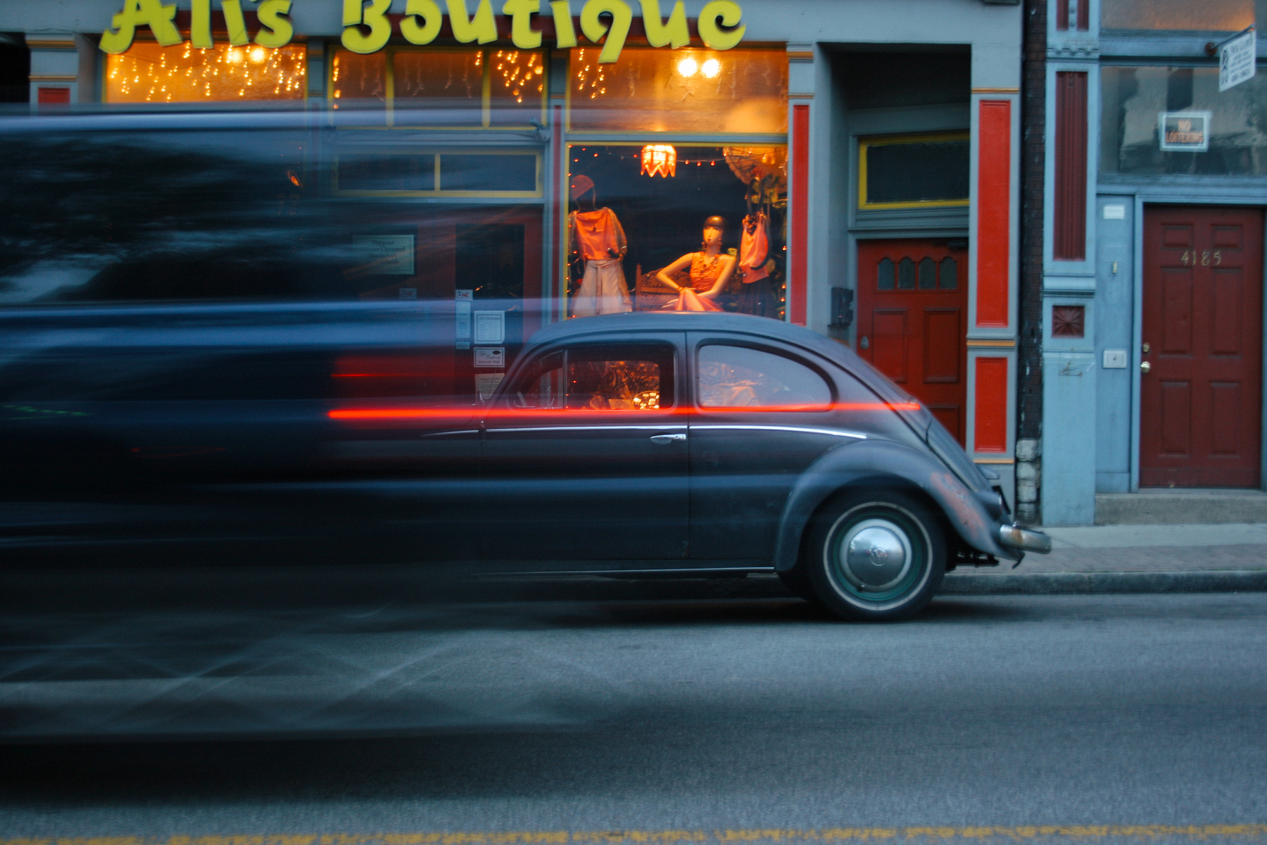 Vehicle blur in front of VW Bug partked outside of a store called Ali's Boutique - Canon EOS 20D