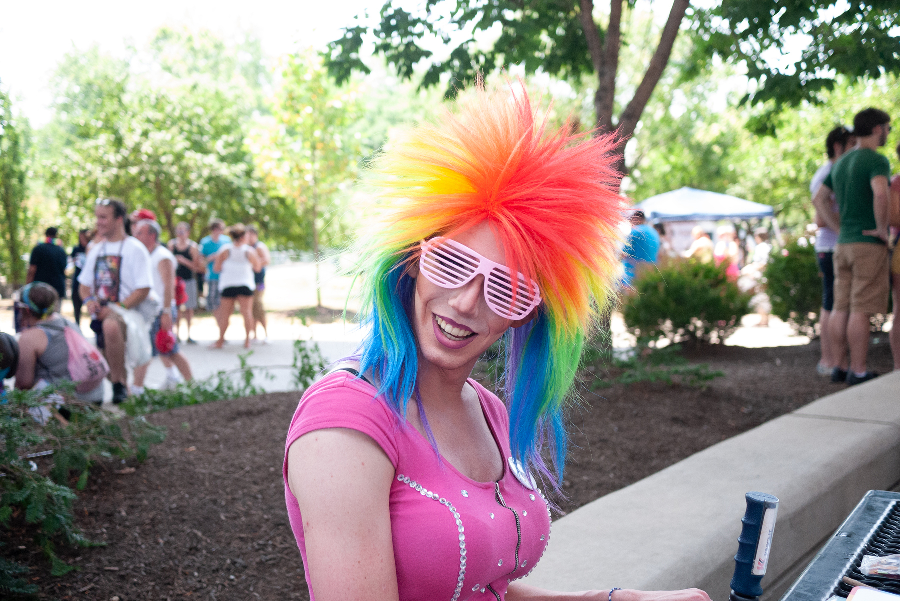 Person with rainbow wig and louvered glasses at a pride celebration - Lumix GF1