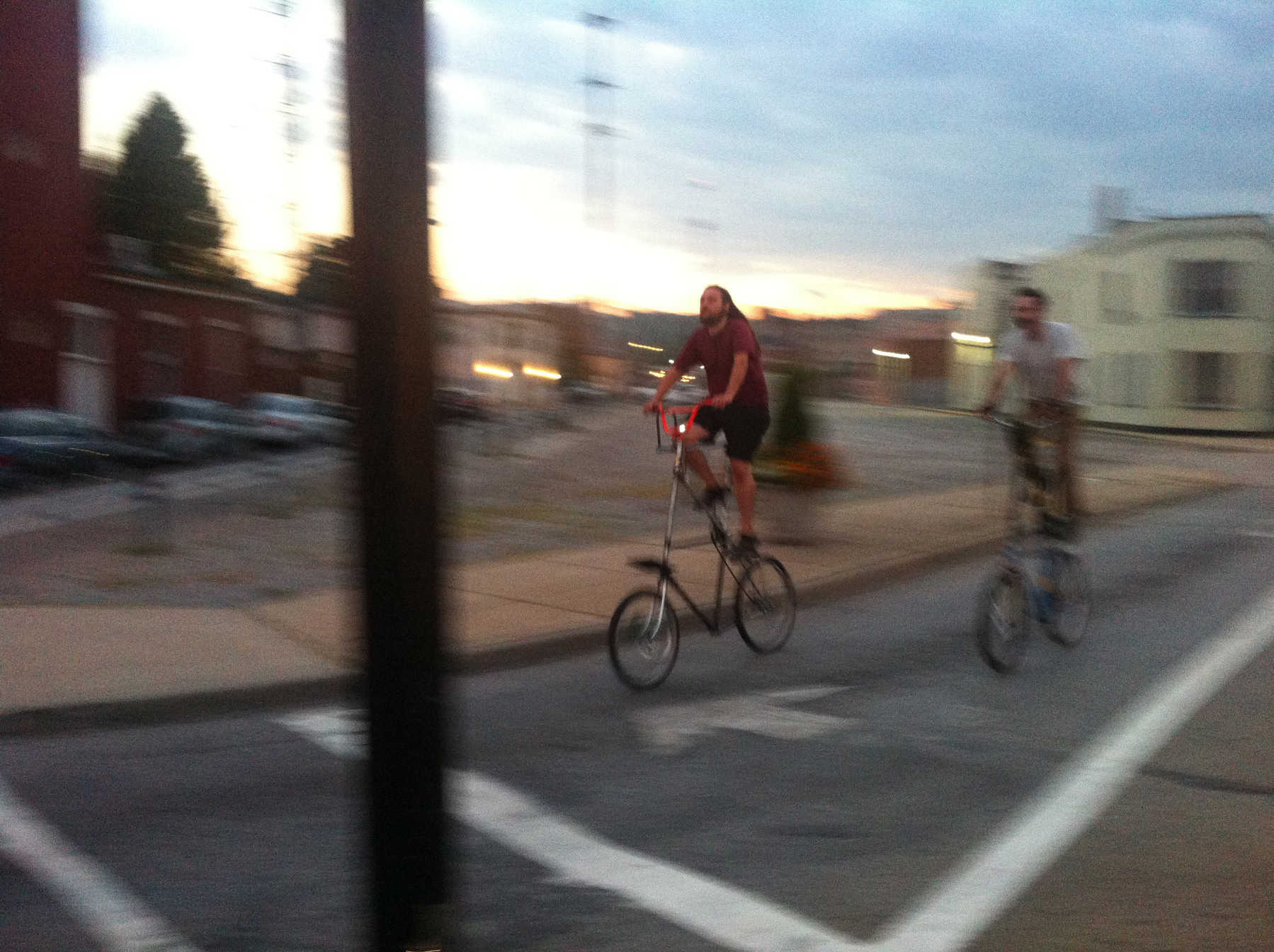 Two folks ride tall bikes in Northside - iPhone 4