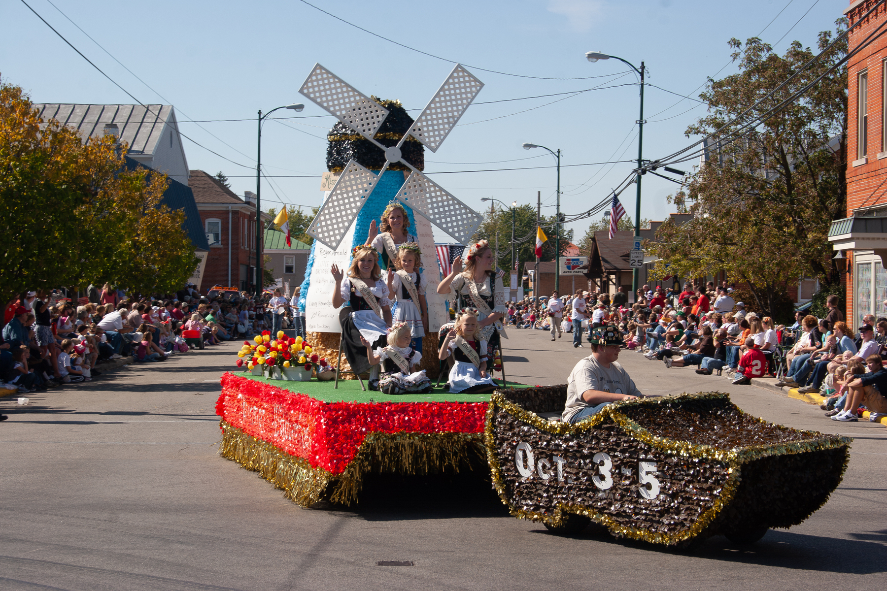 Ladies in German Dutch garb ride a float with a windmill pulled by a man driving small vehicle decorated as a wooden shoe - Canon 20D