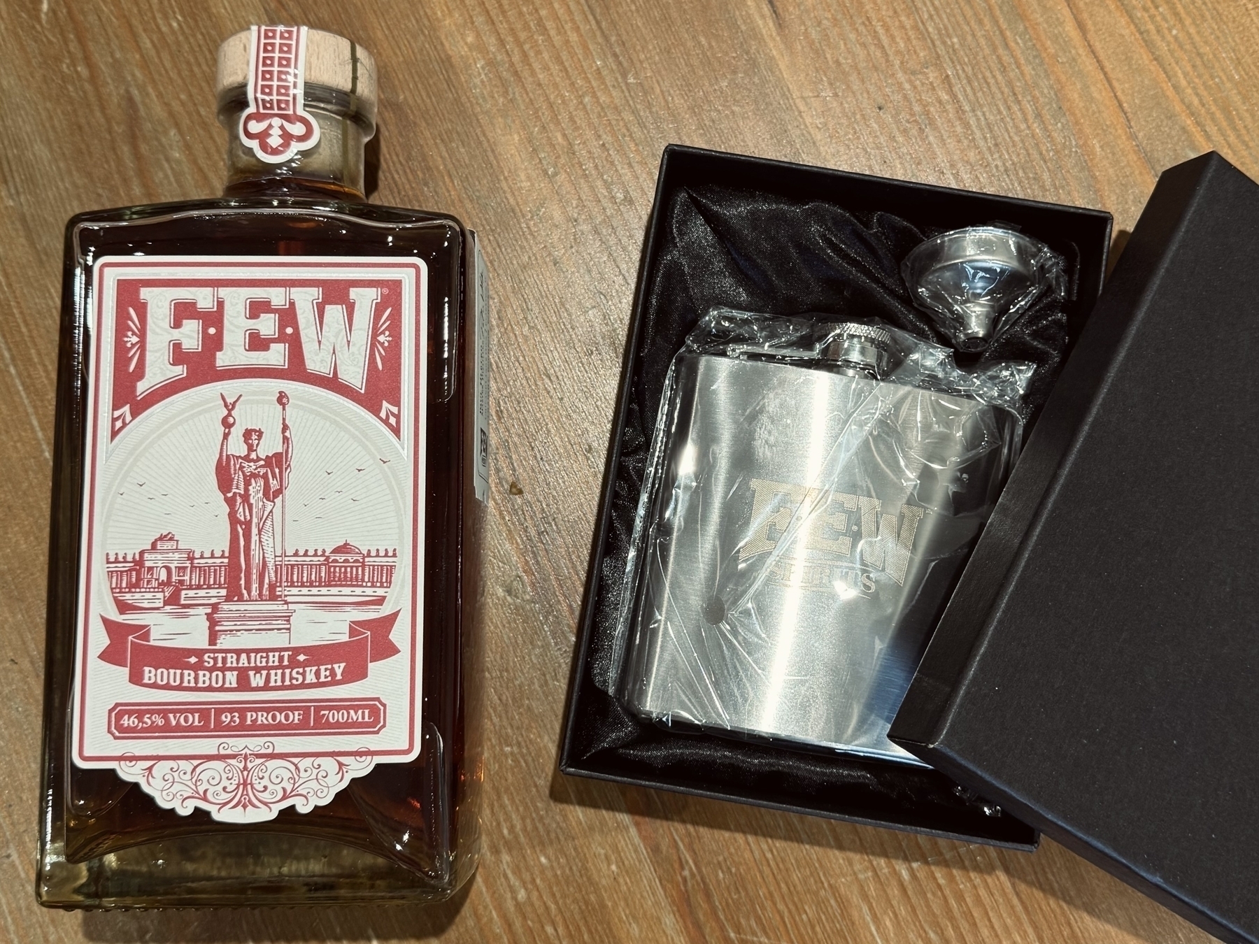 a bottle of FEW American bourbon and a silver hip flask in a decorative box