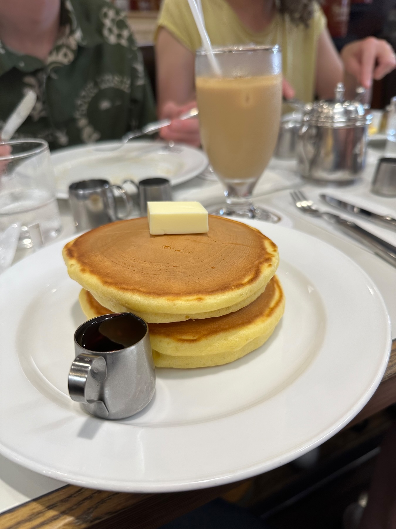 A plate of &ldquo;hot cake&rdquo; pancakes with  tiny jug of maple syrup on the side