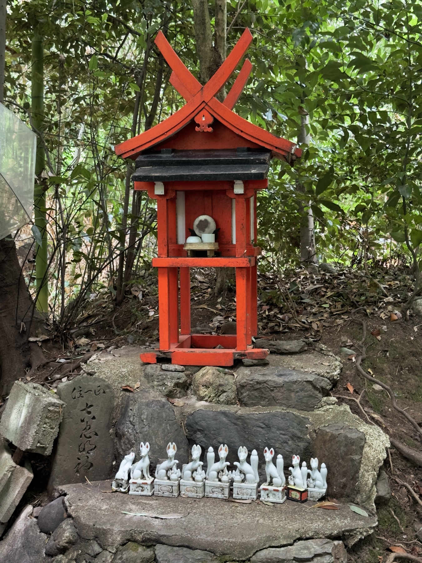A small shrine with fox statues on a stone