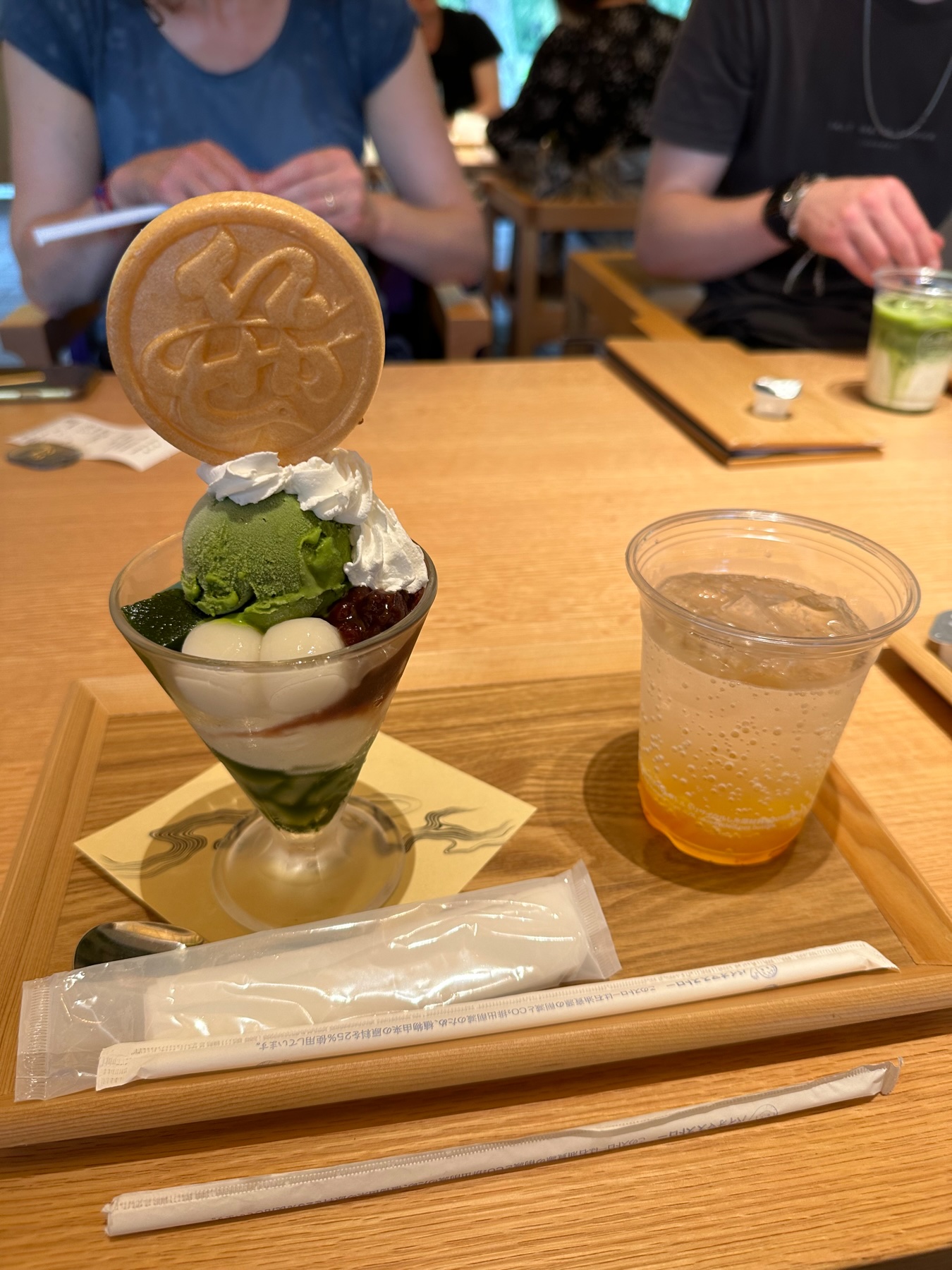 A Matcha Parfait and yuzu soda on a wooden tray