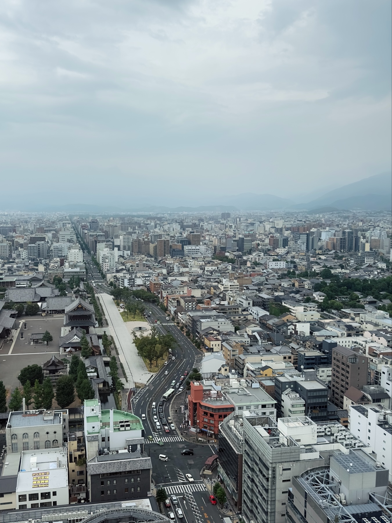 A view of a central highway next to a large temple viewed from Kyoto Tower