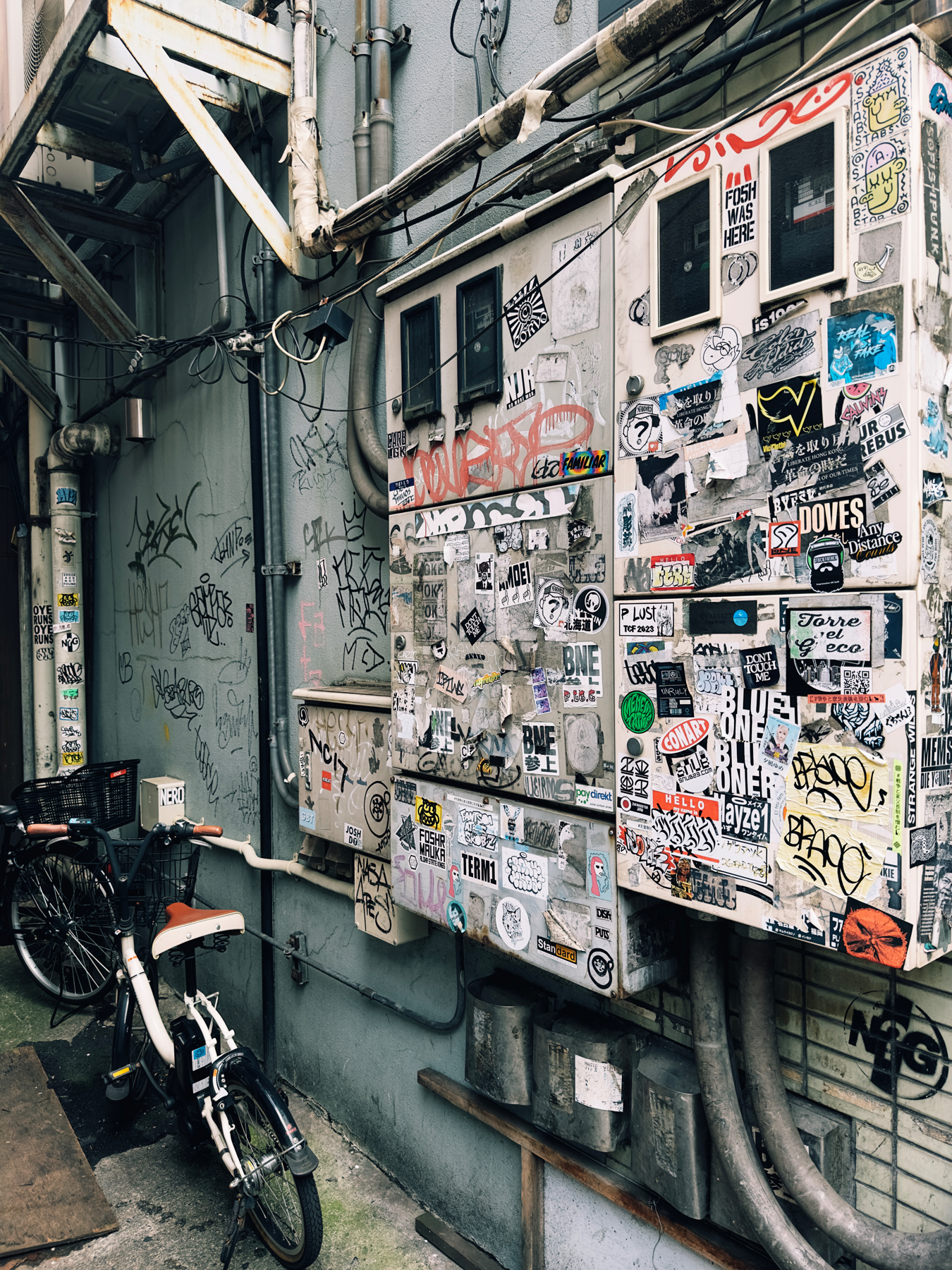 A sticker encrusted air conditioning unit on the backstreets of Tokyo