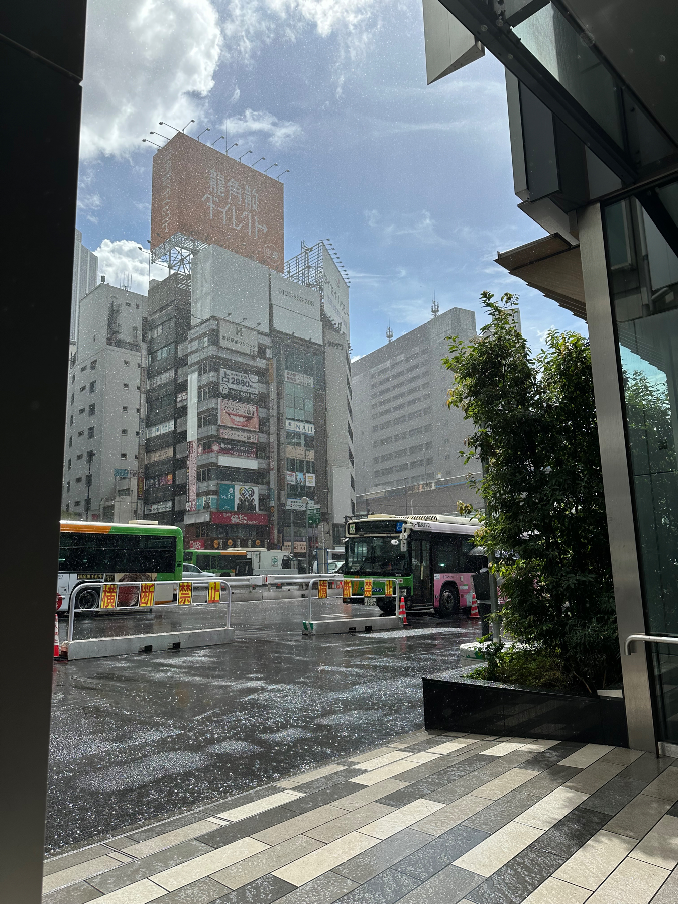 The rain pouring onto Shibuya bus station whilst the sun still shines