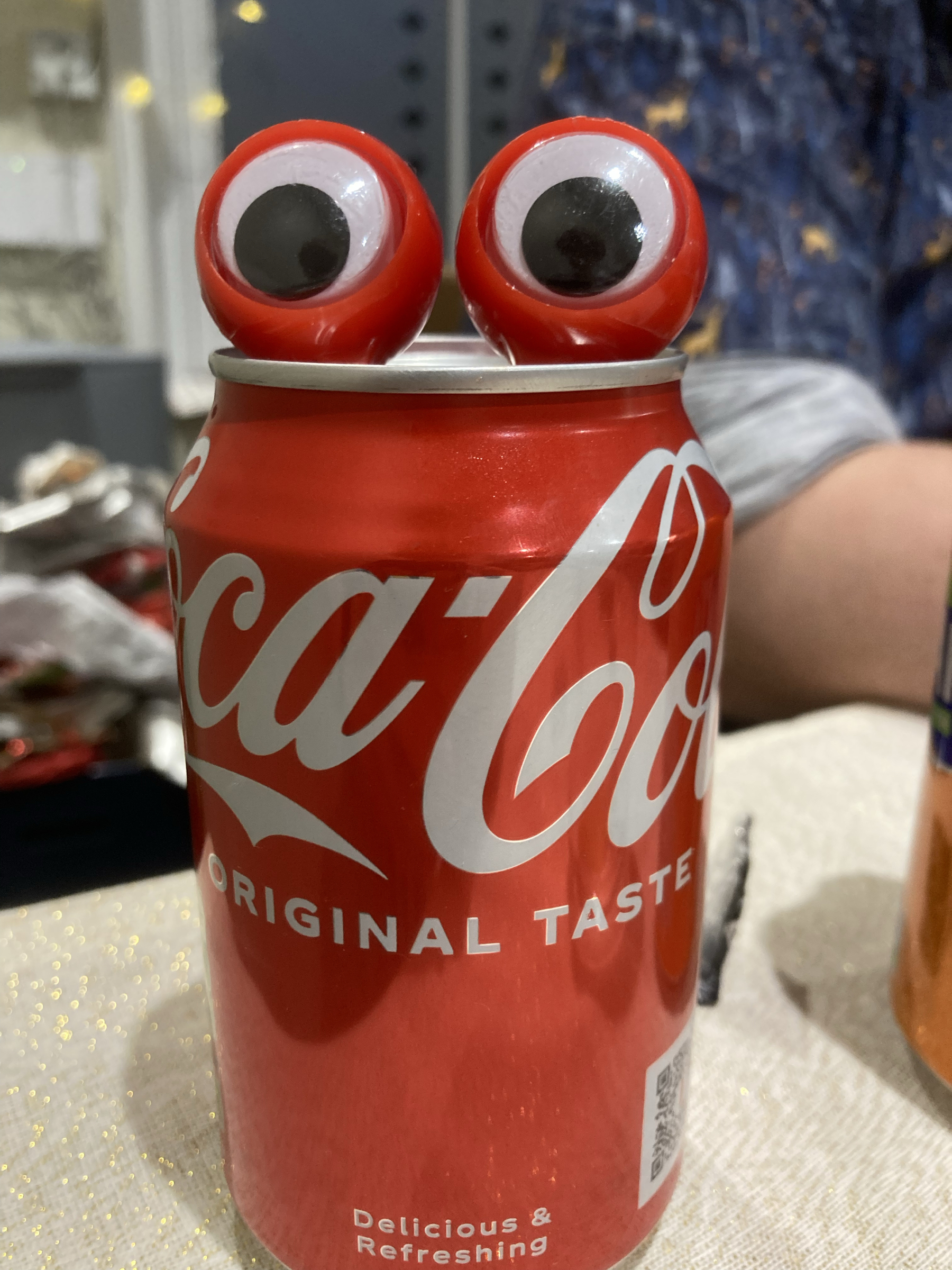 a can of coke with googly eyes on the top