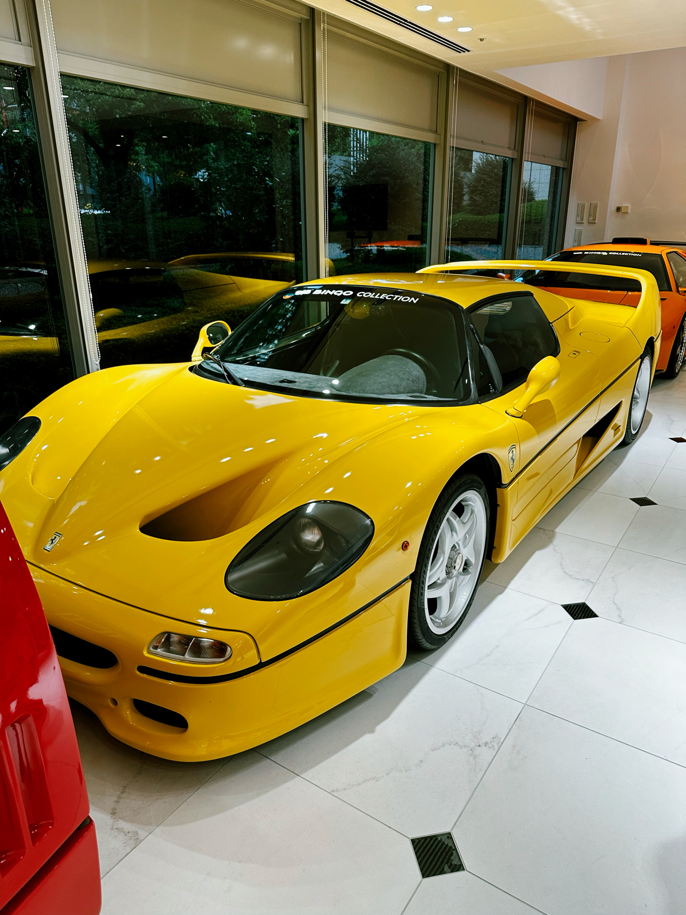 A bright yellow Ferrari F50 supercar shining in a showroom