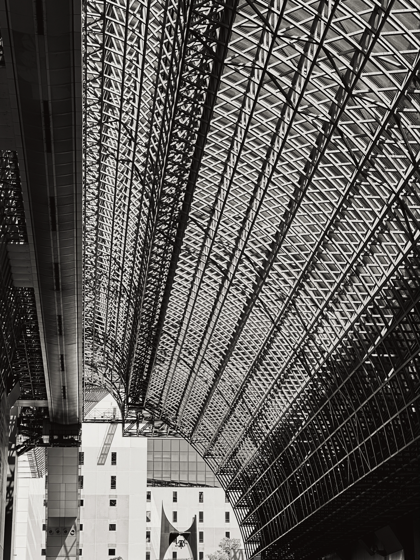 A black and white photo showing the metal and glass lattice that makes up the ceiling