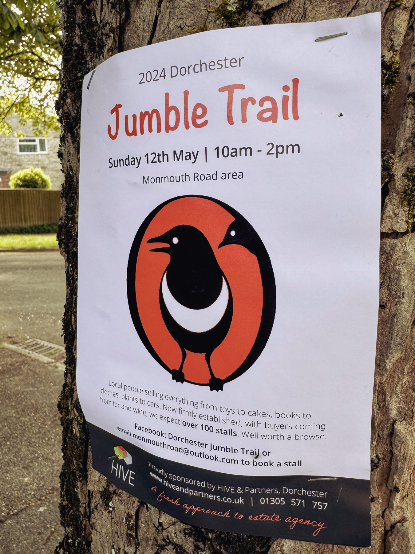 A poster for the jumble train stapled to a tree showing the logo of a magpie against an orange background.