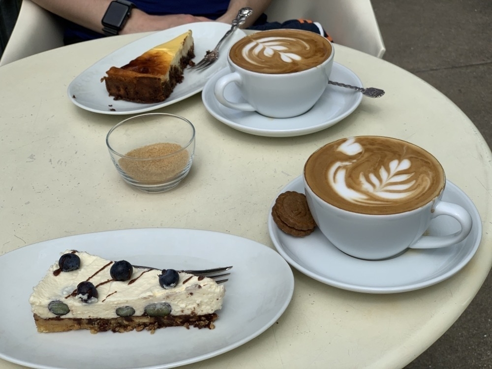 Two cakes and two cappuccino on a table. 