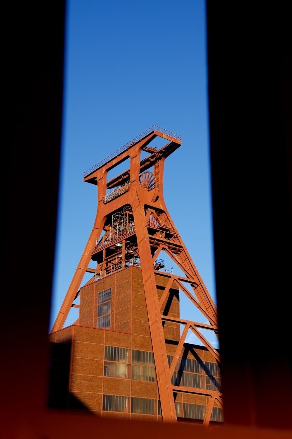 Photo of the winding tower of the Zollverein colliery, framed in a steel outline.