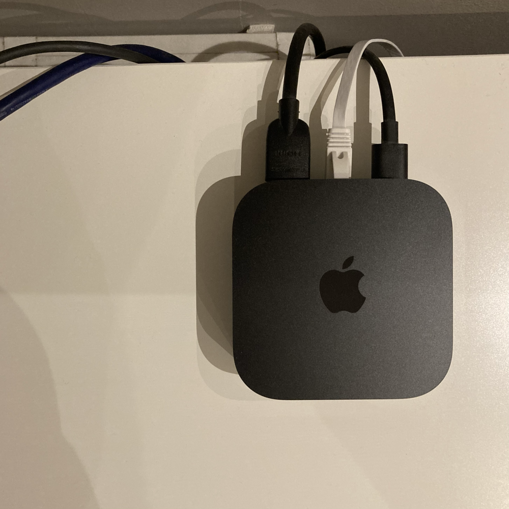 Apple TV with connected flat ethernet cable in the middle.