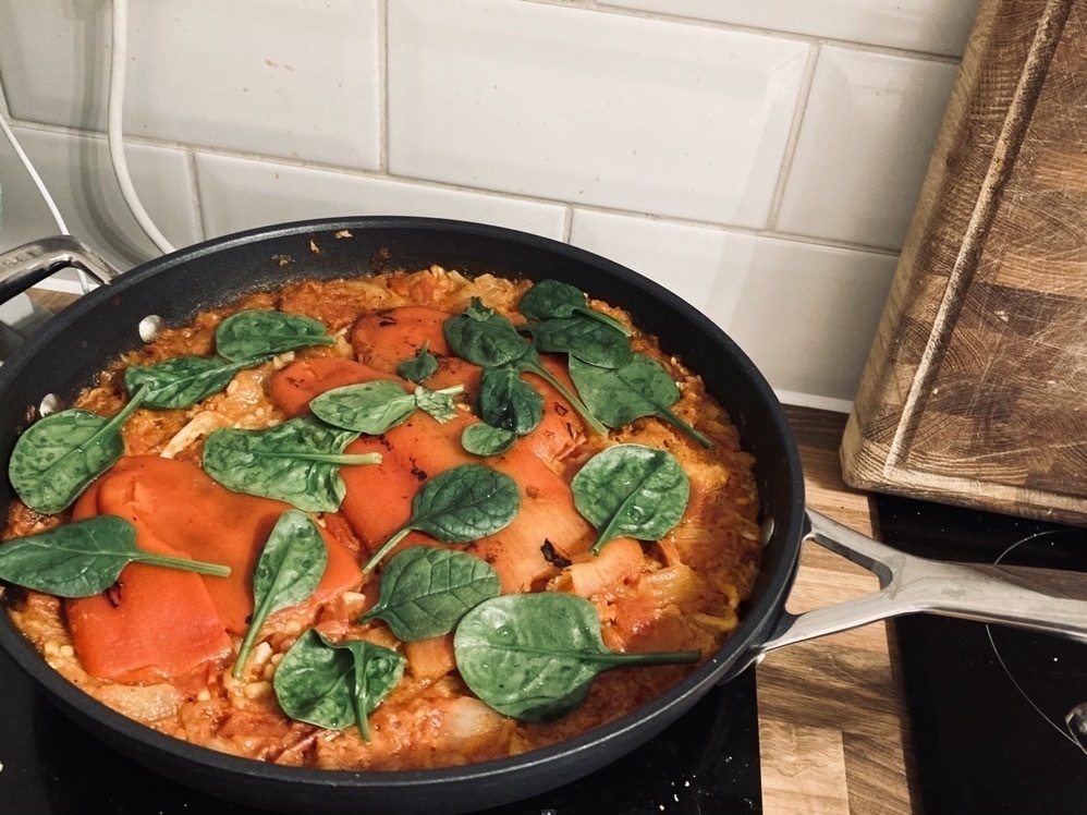 Paella topped with spinach