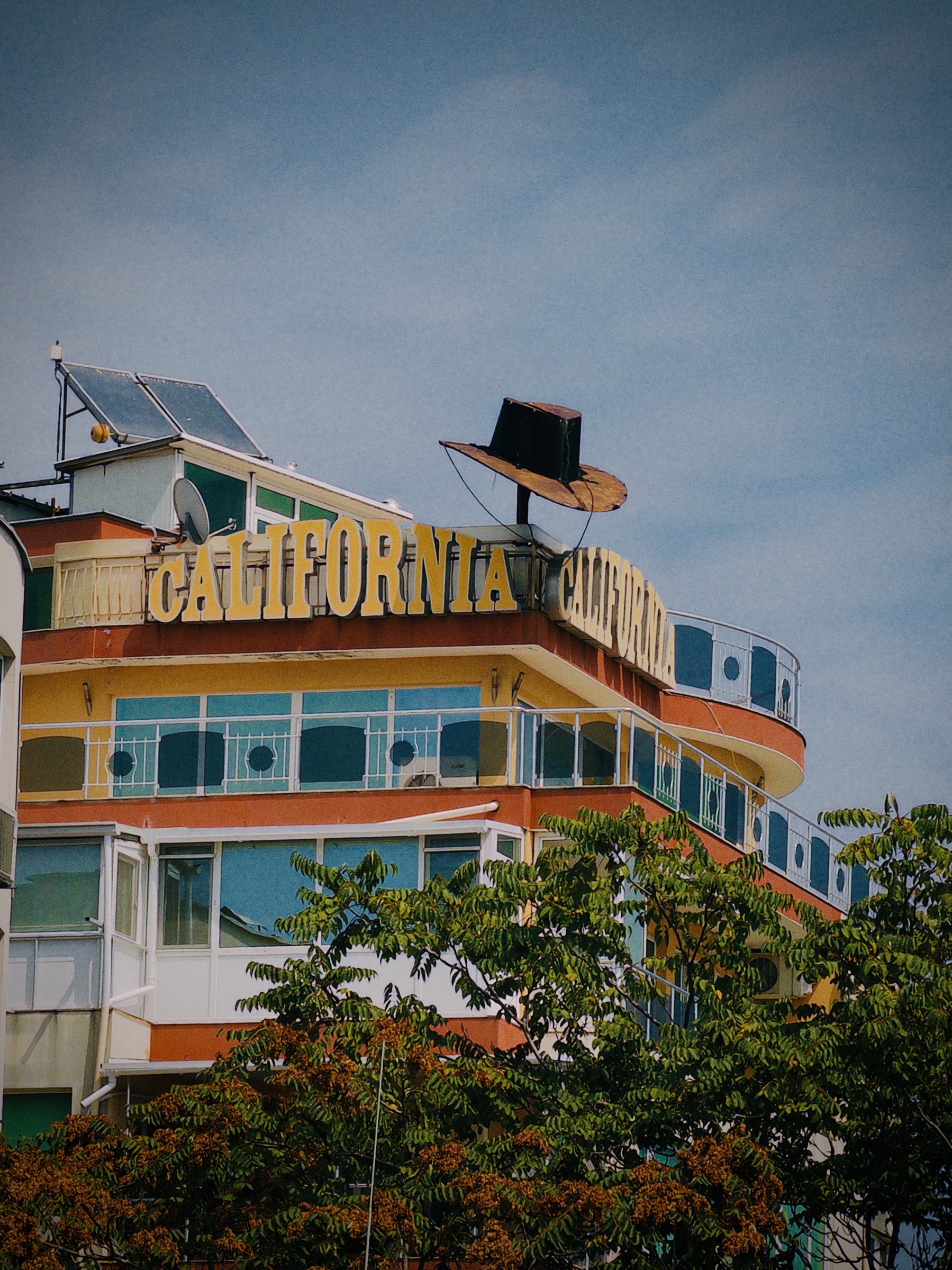 A rooftop with solar panel, cowoby hat decoration and californa sign