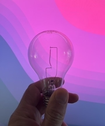 An old filament bulb with colorful background from a Fedora desktop