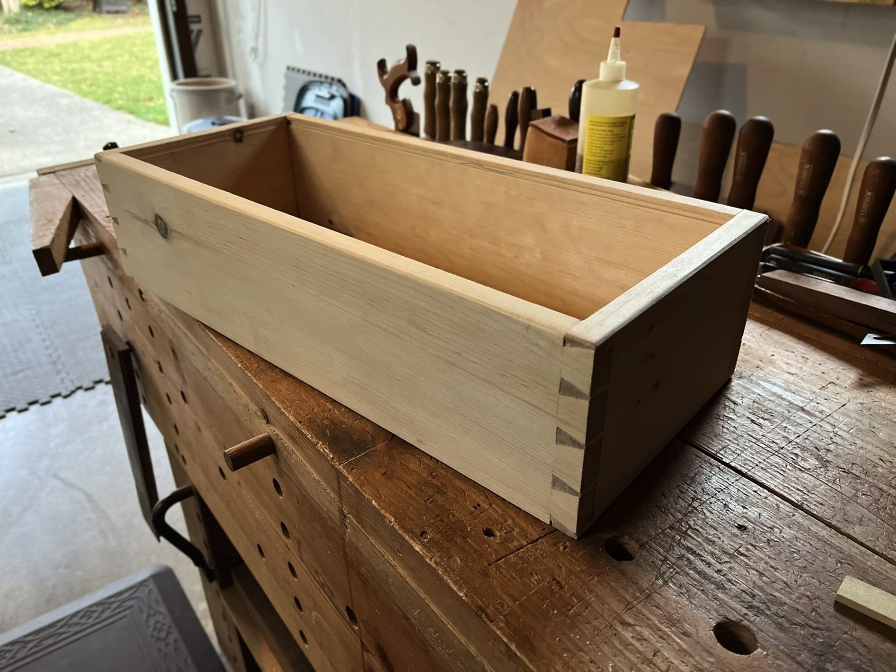 A small pine dovetailed box on a workbench