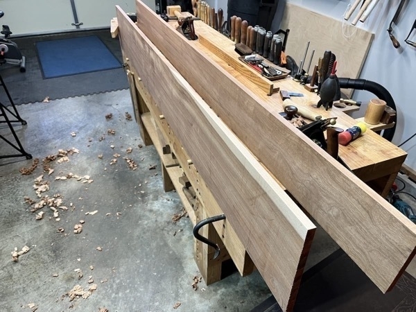 two 8 foot sapele boards on workbench, edge facing up to flatten them