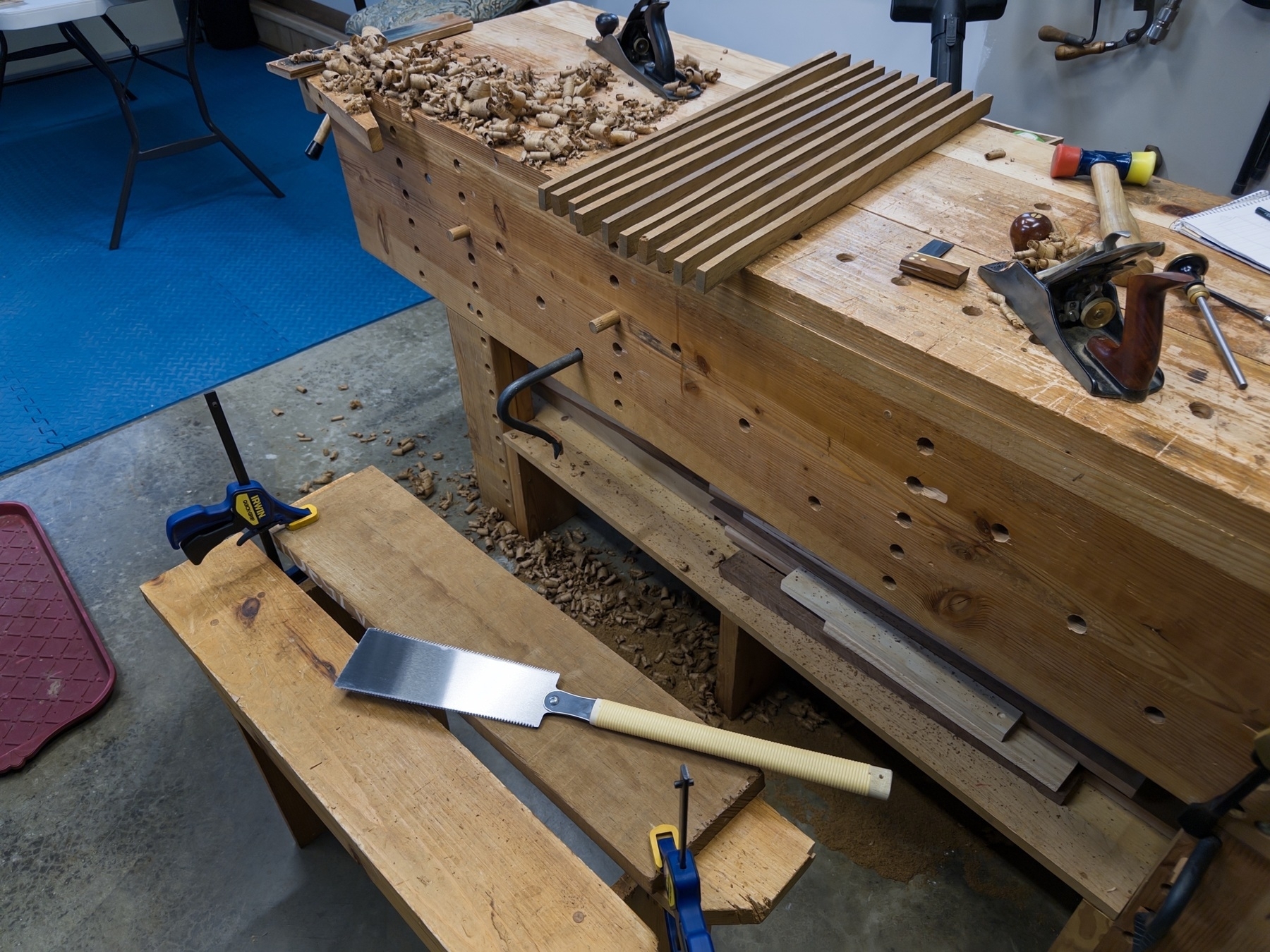 Cutting teak into strips in a workshop with a Japanese saw