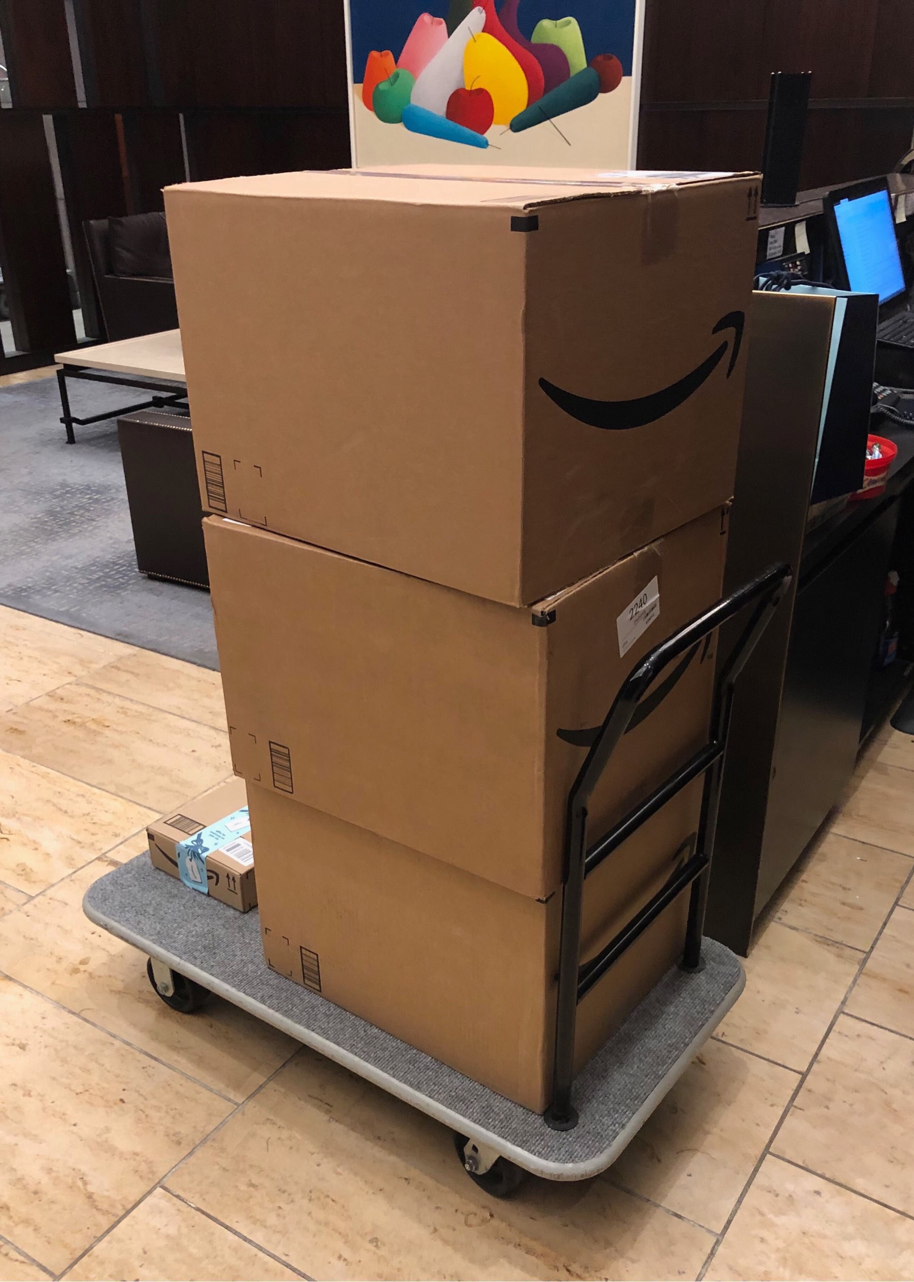 Three large amazon boxes on a rolling cart.
