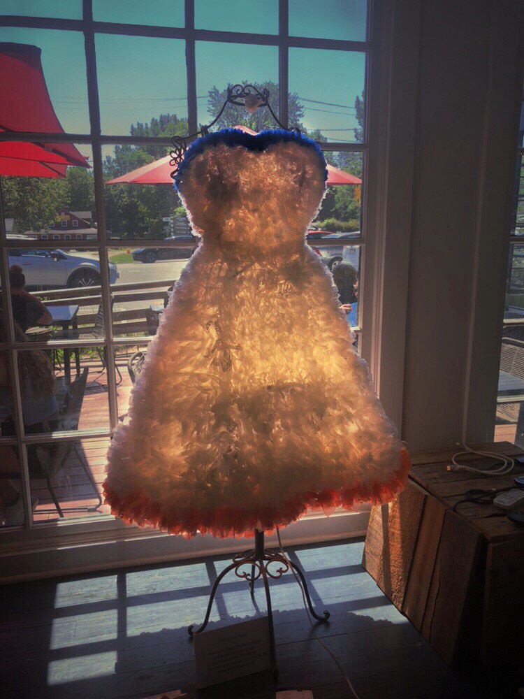 Dress made out of plastic bags, glowing from sun through windows.