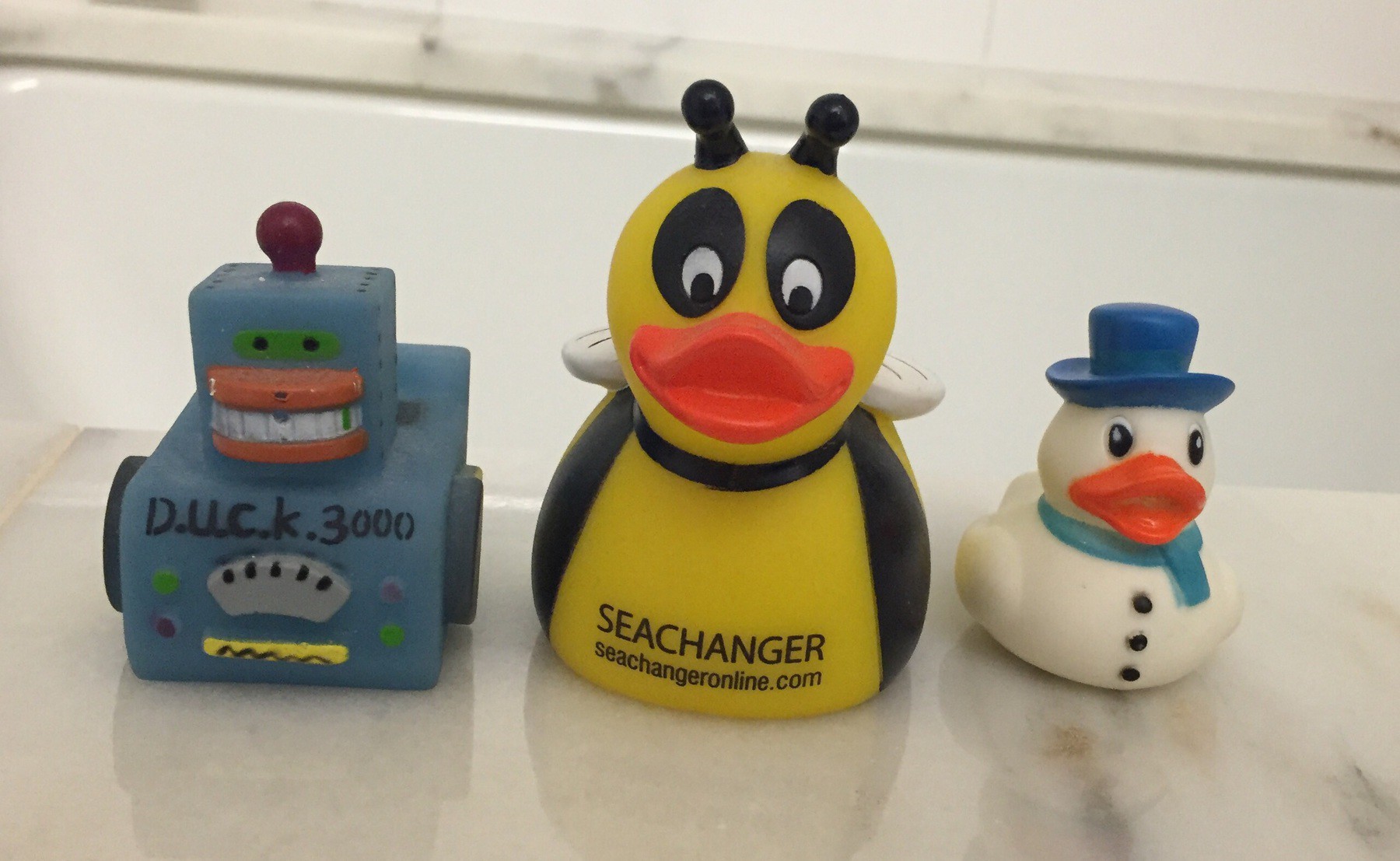 Three plastic ducks—robot duck 3000, bumblebee duck, and snowman duck.