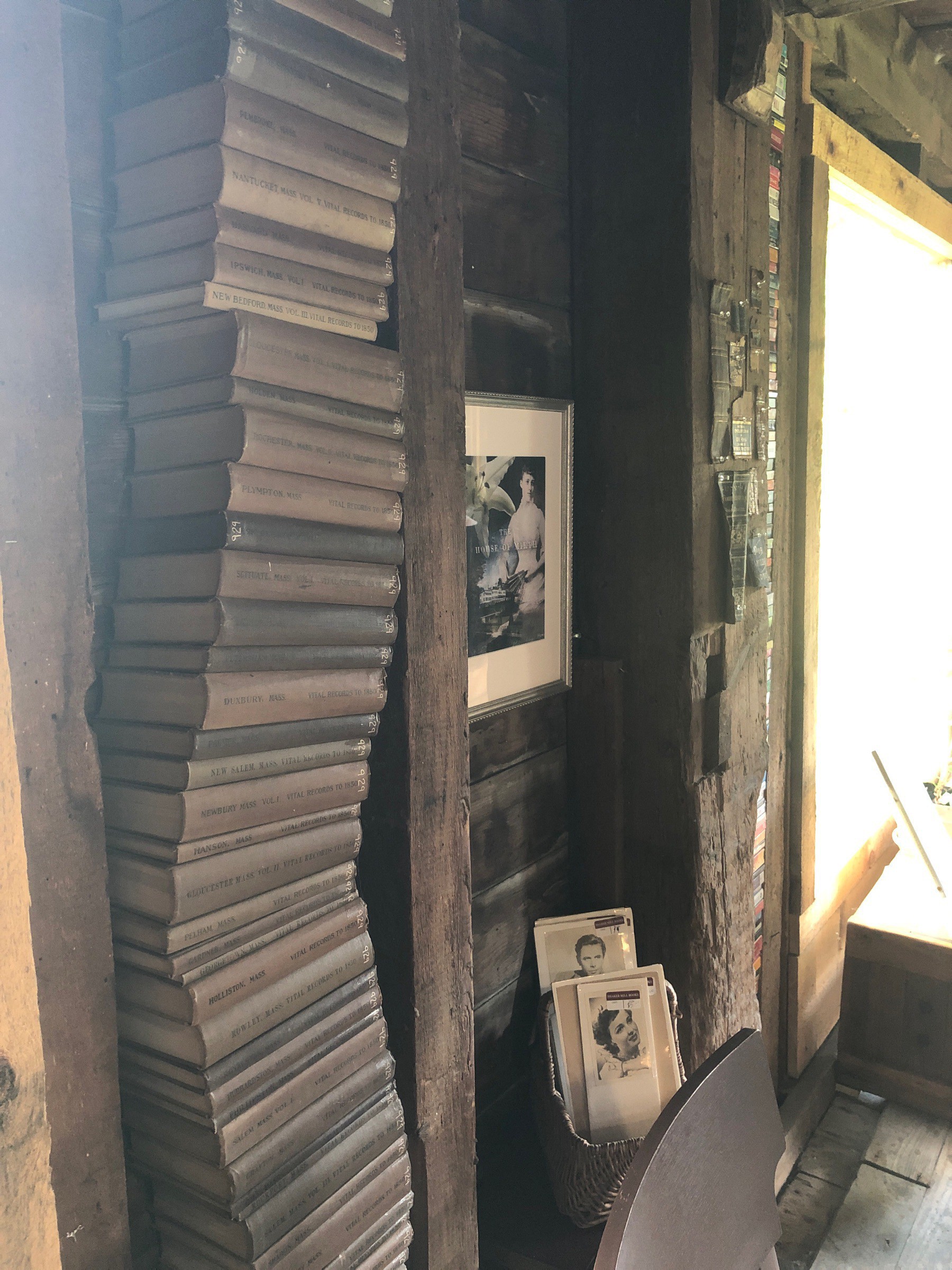 A tall stack of old books in a barn.