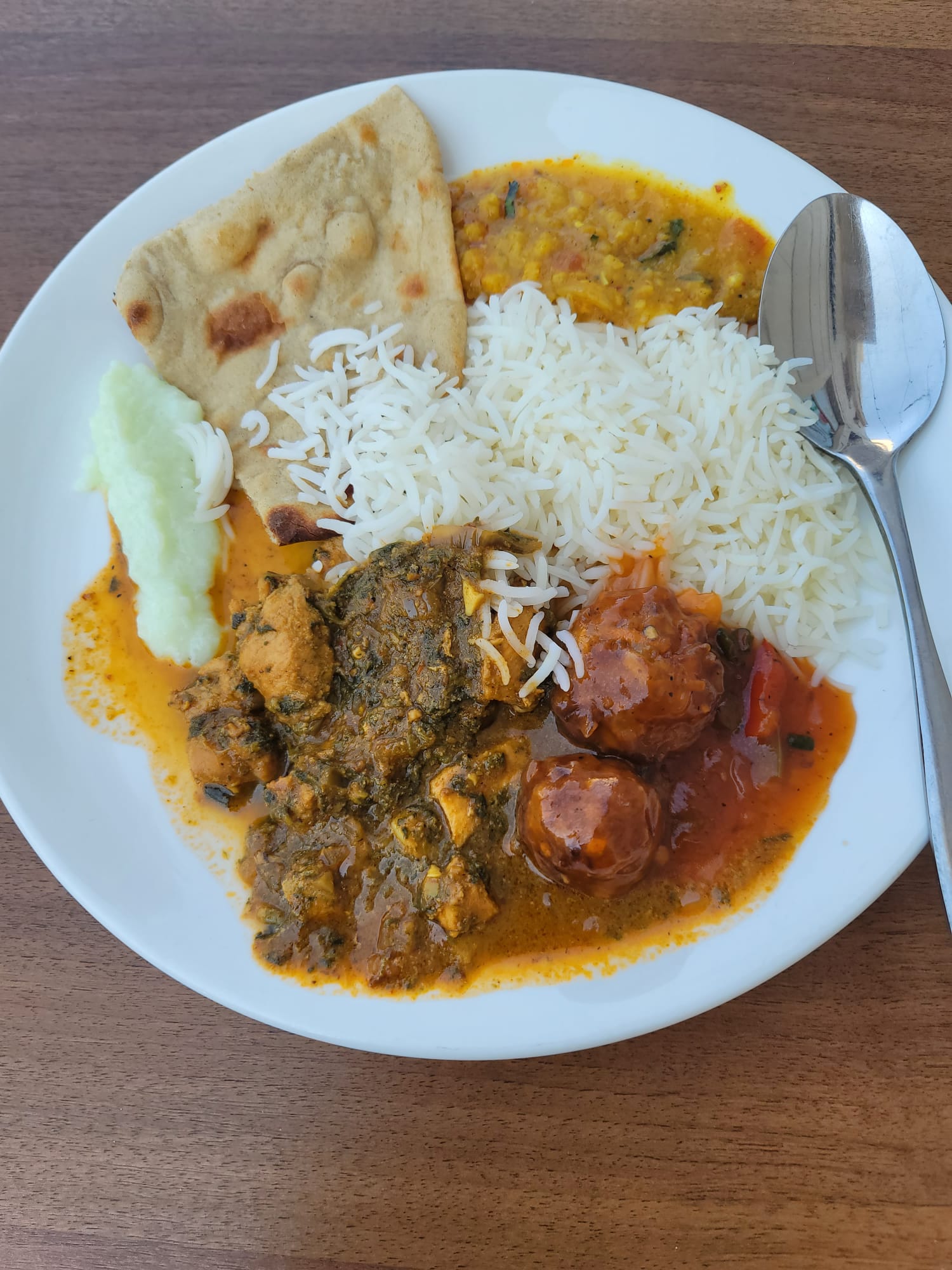 plate with rice, naan, and various curries