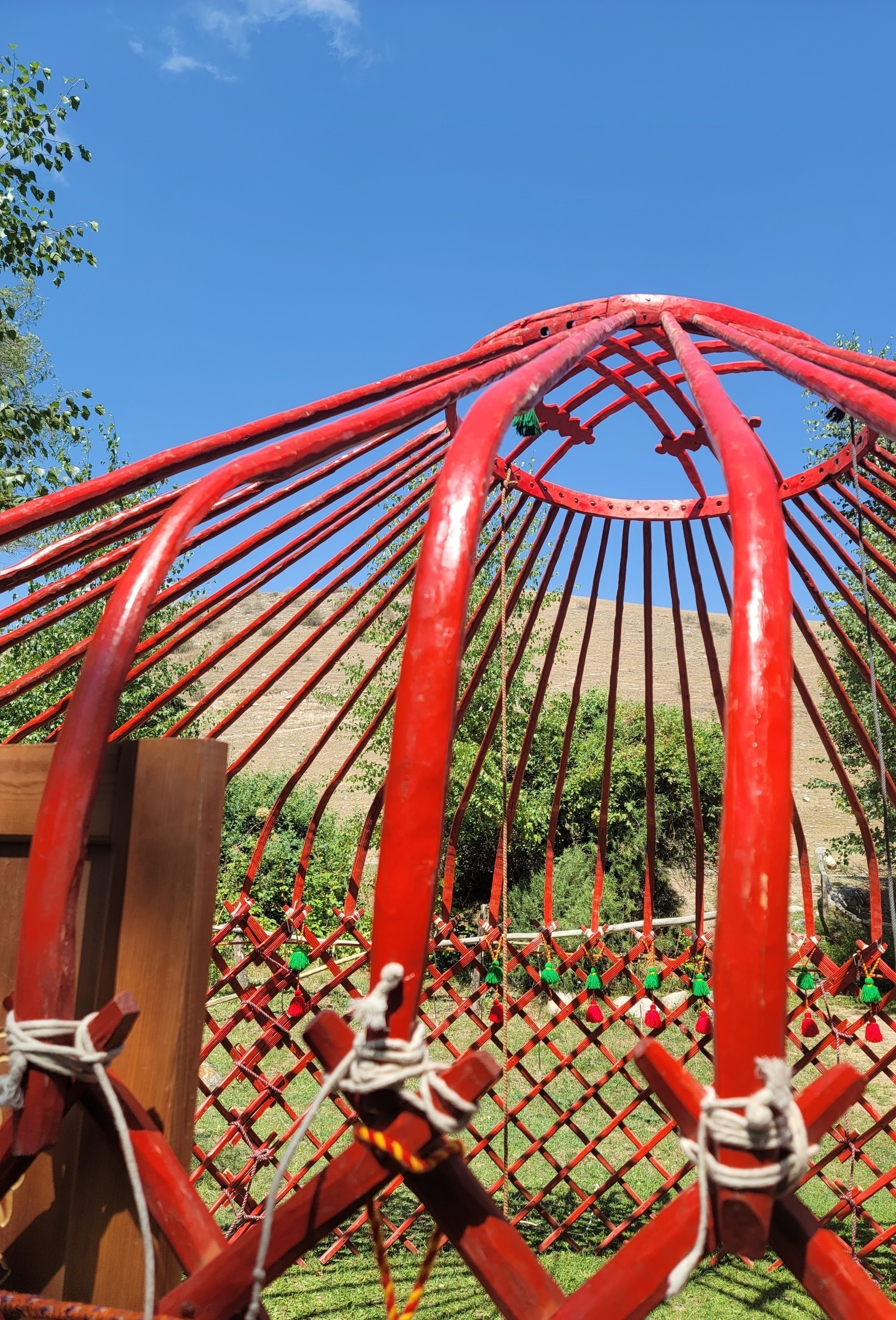 assembled red skeleton of a yurt without any felt coverings