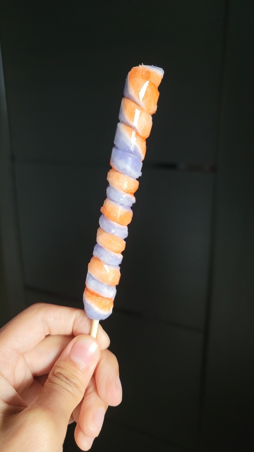 orange and purple colored sugar coils around a stick to look like a lollipop