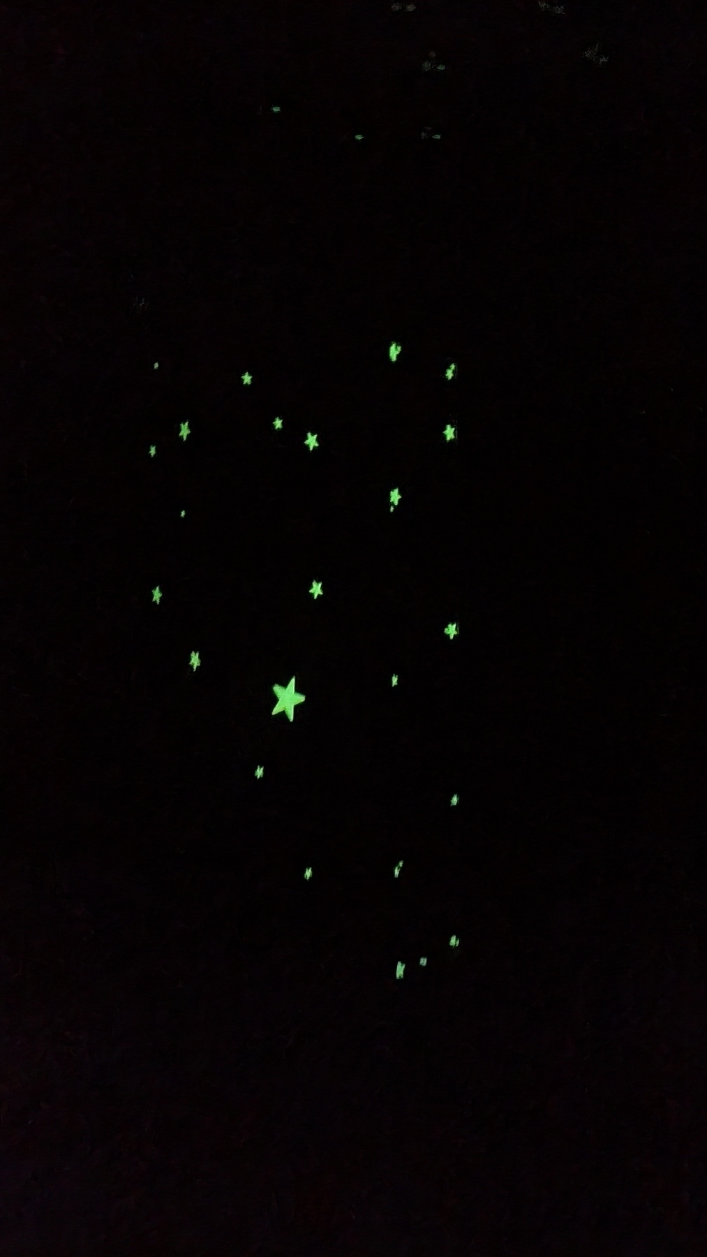 glow in the dark stars of different sizes seen glowing in the dark