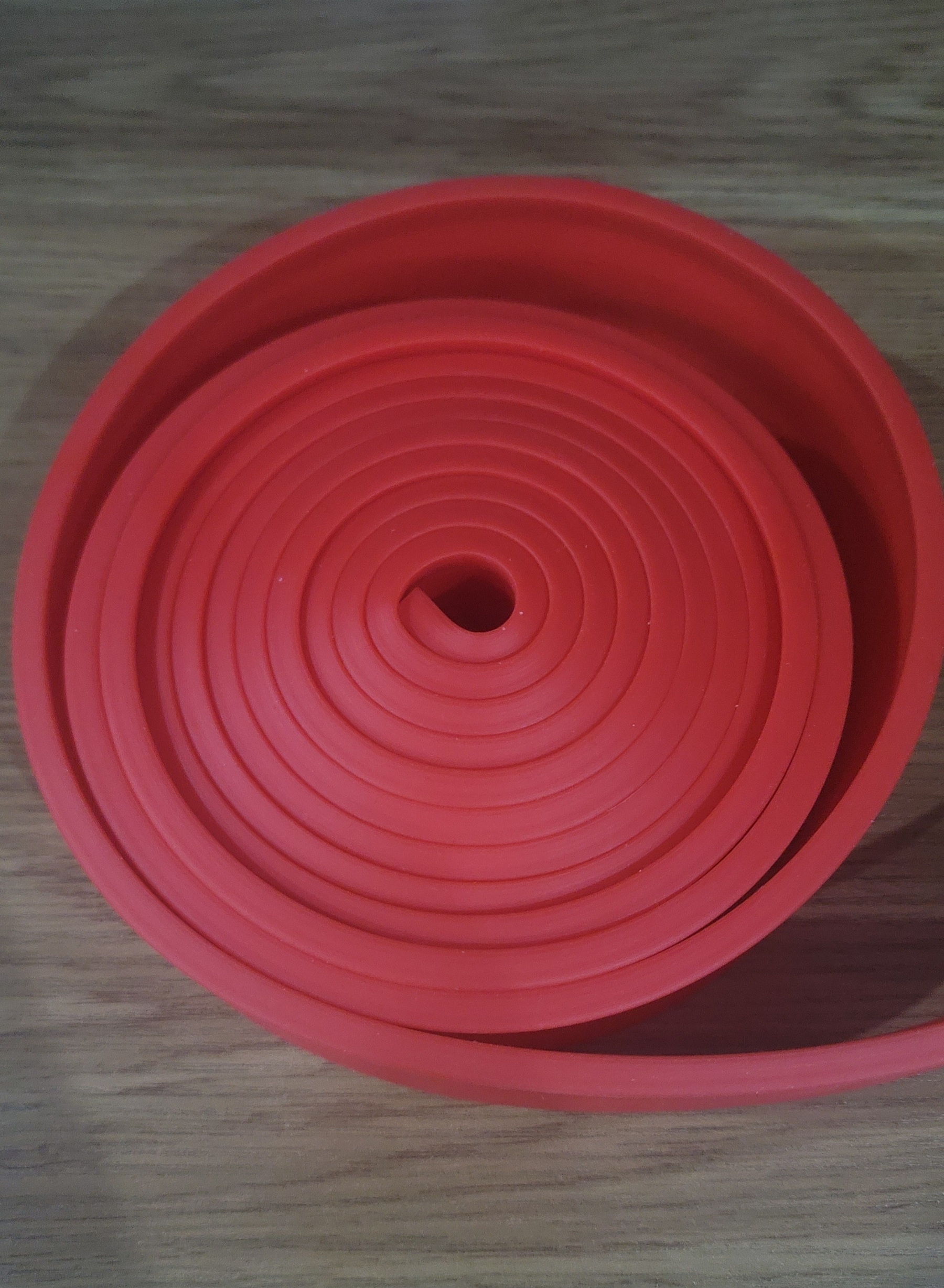 red resistance band on a desk rolled up in a circular shape
